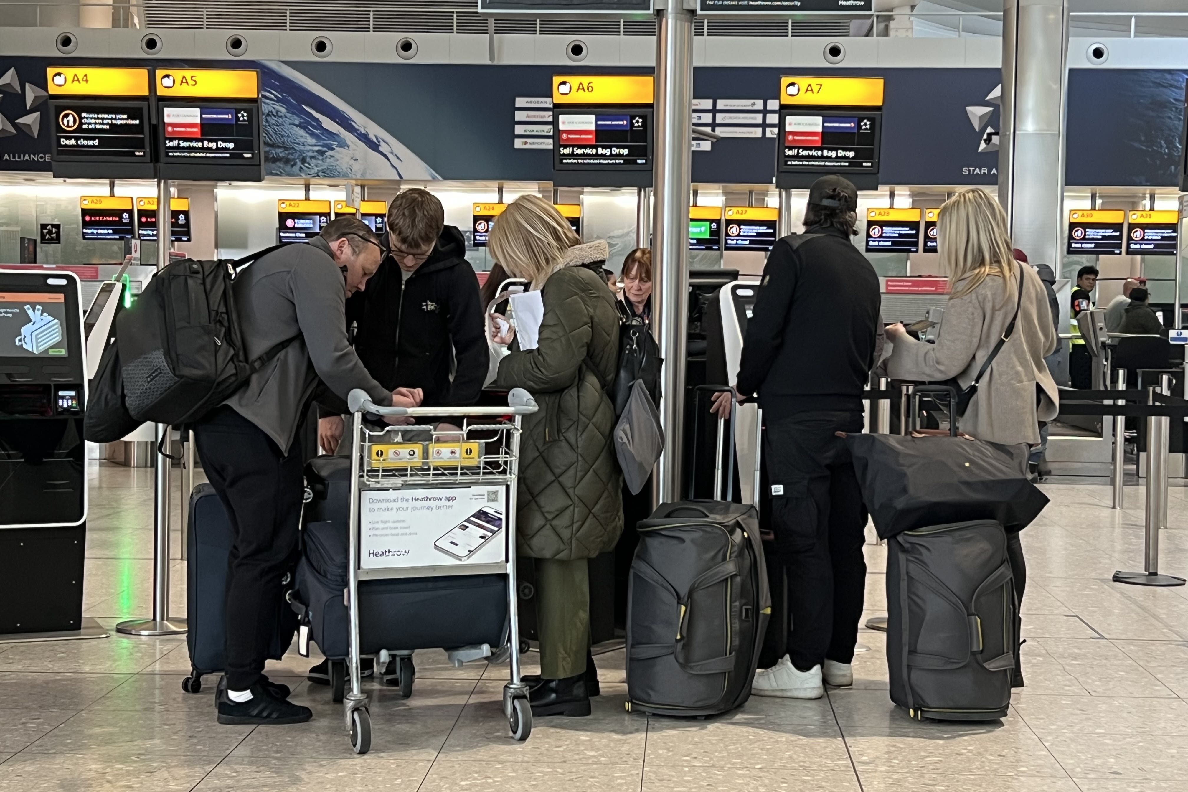 Passengers queue at a check-in desk at Heathrow’s terminal 2