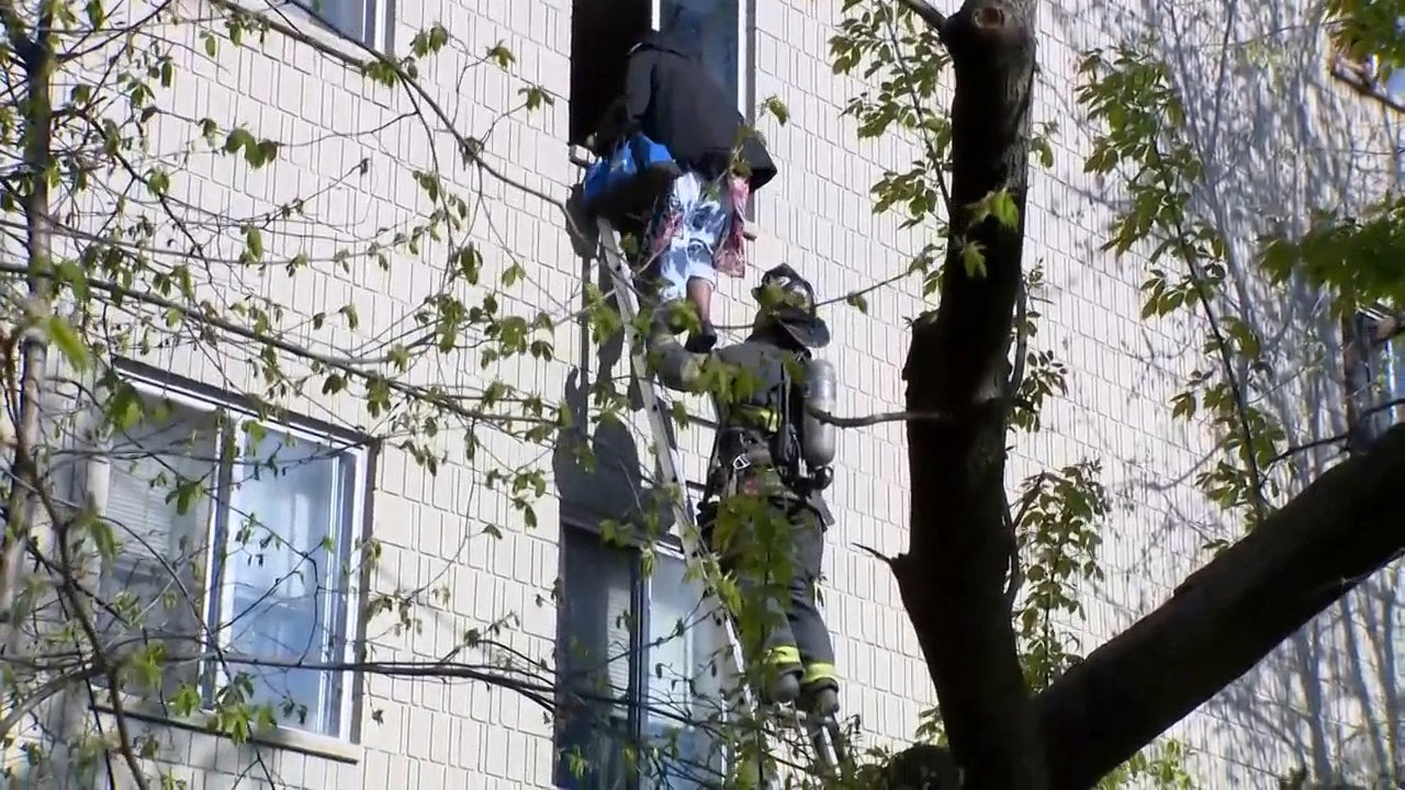 A firefighter helping a resident to exit the building after the devastating fire