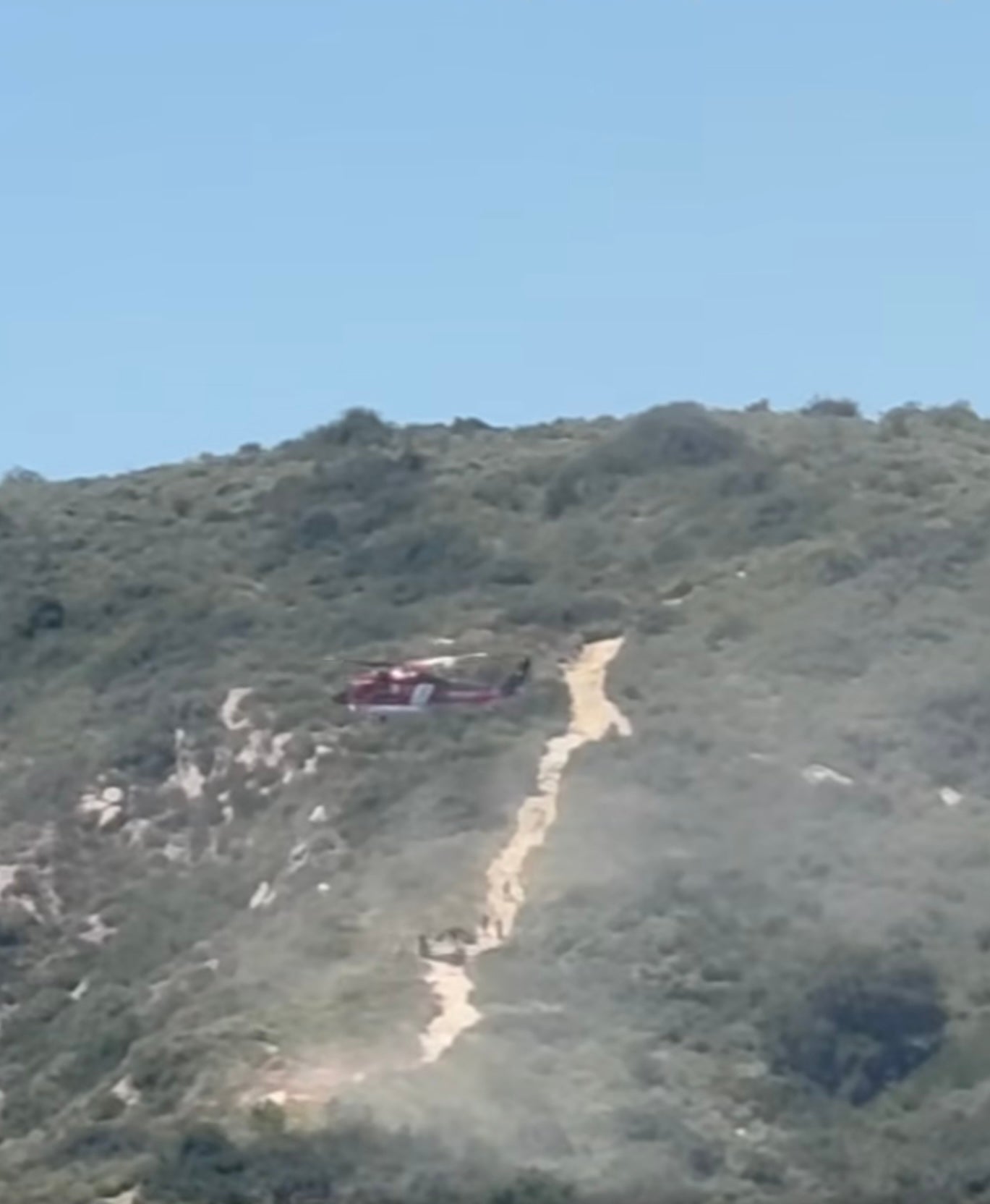 An Orange County firefighting helicopter works to rescue stranded hikers in Aliso and Wood Canyons Wilderness Park