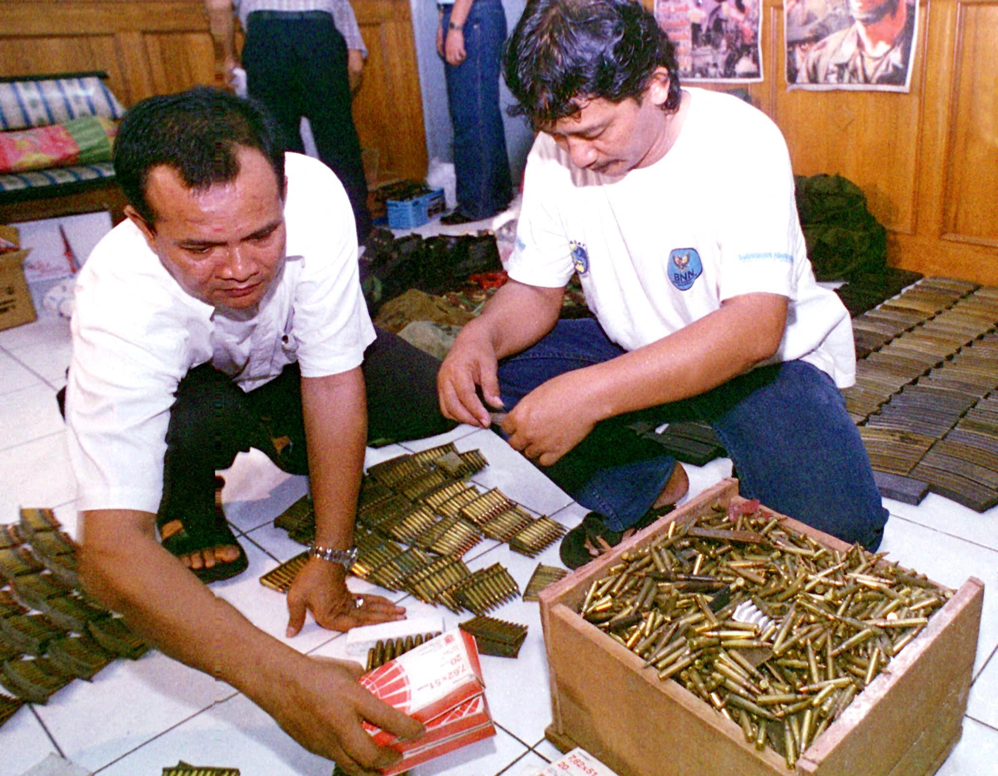 Representational. Two plainclothes policemen hold bullets. File