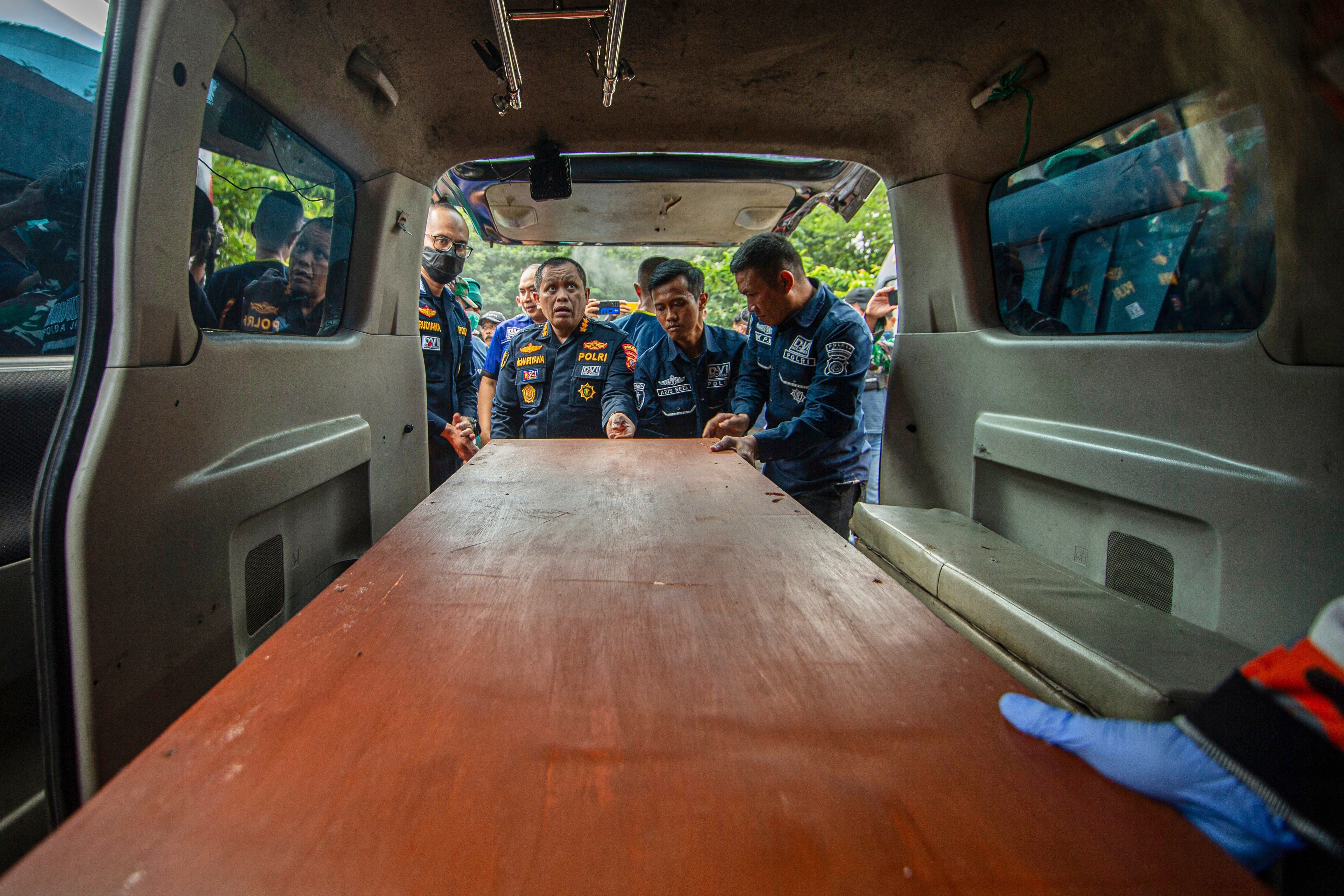 Police officers load a casket in Garut, West Java, Indonesia