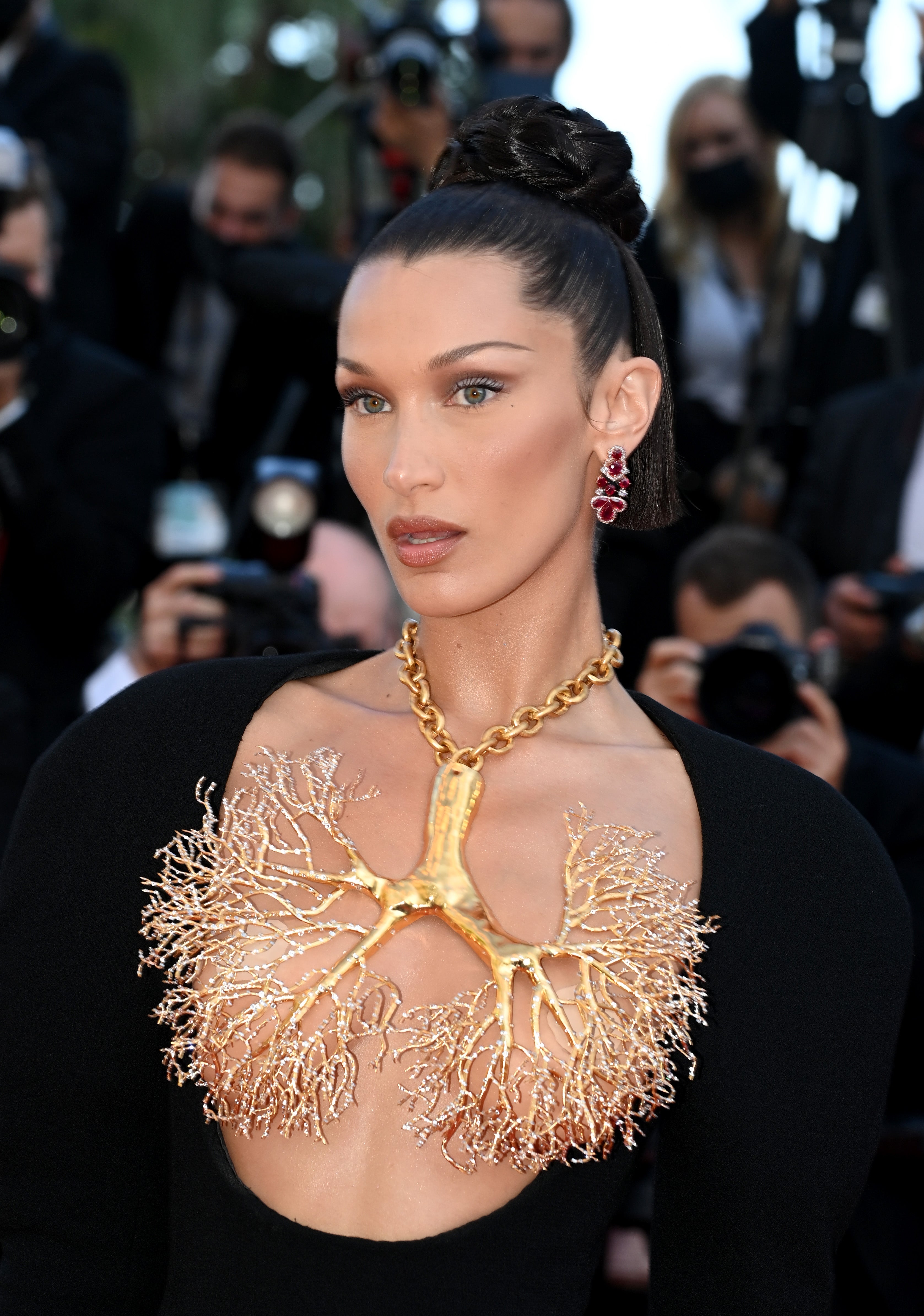 Hadid’s bare chest was barely covered by a large, upside-down gold tree with thin branches hanging from her neck