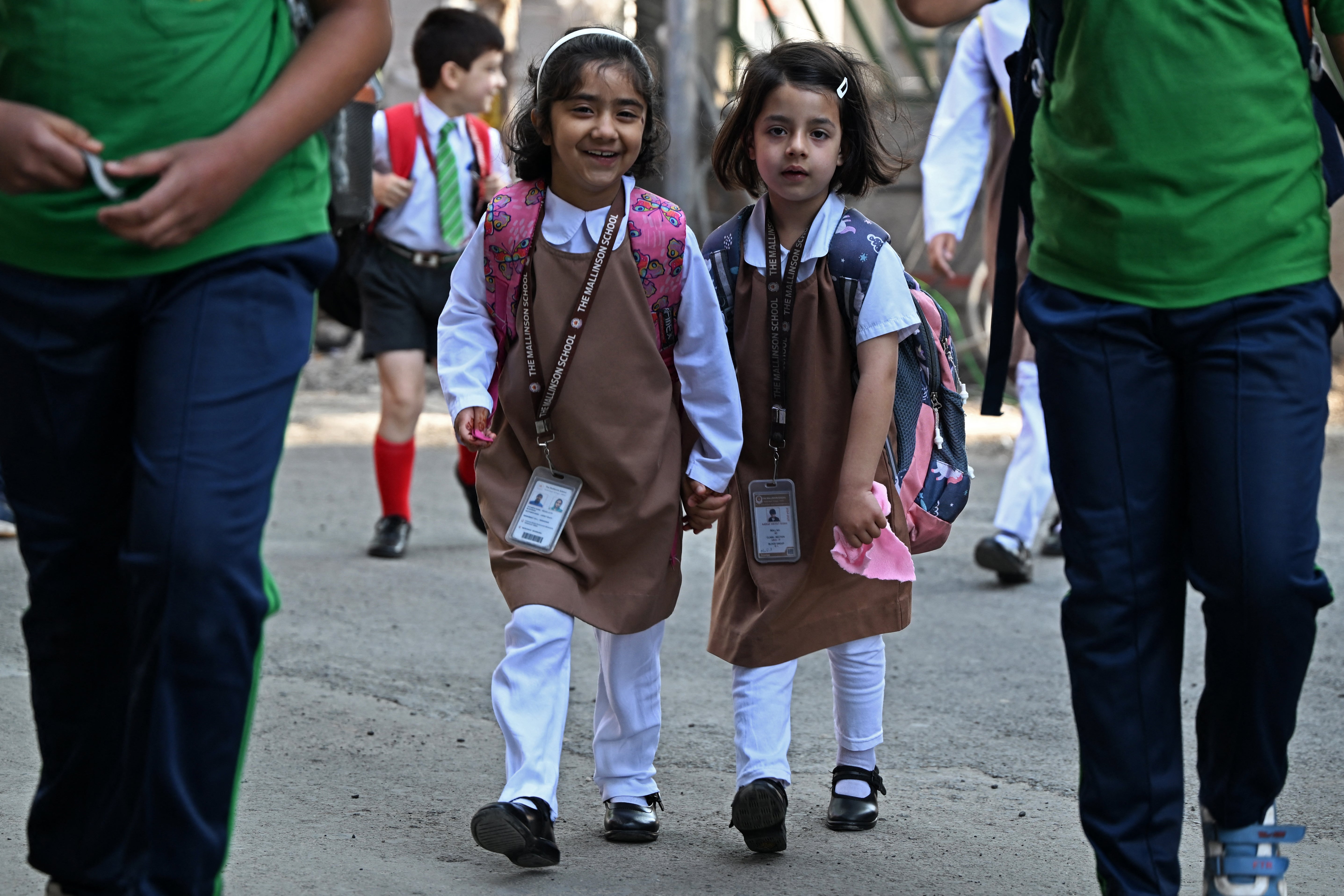 Students walk to attend classes as their school reopened after a ceasefire between Pakistan and India, in Srinagar on 13 May 2025