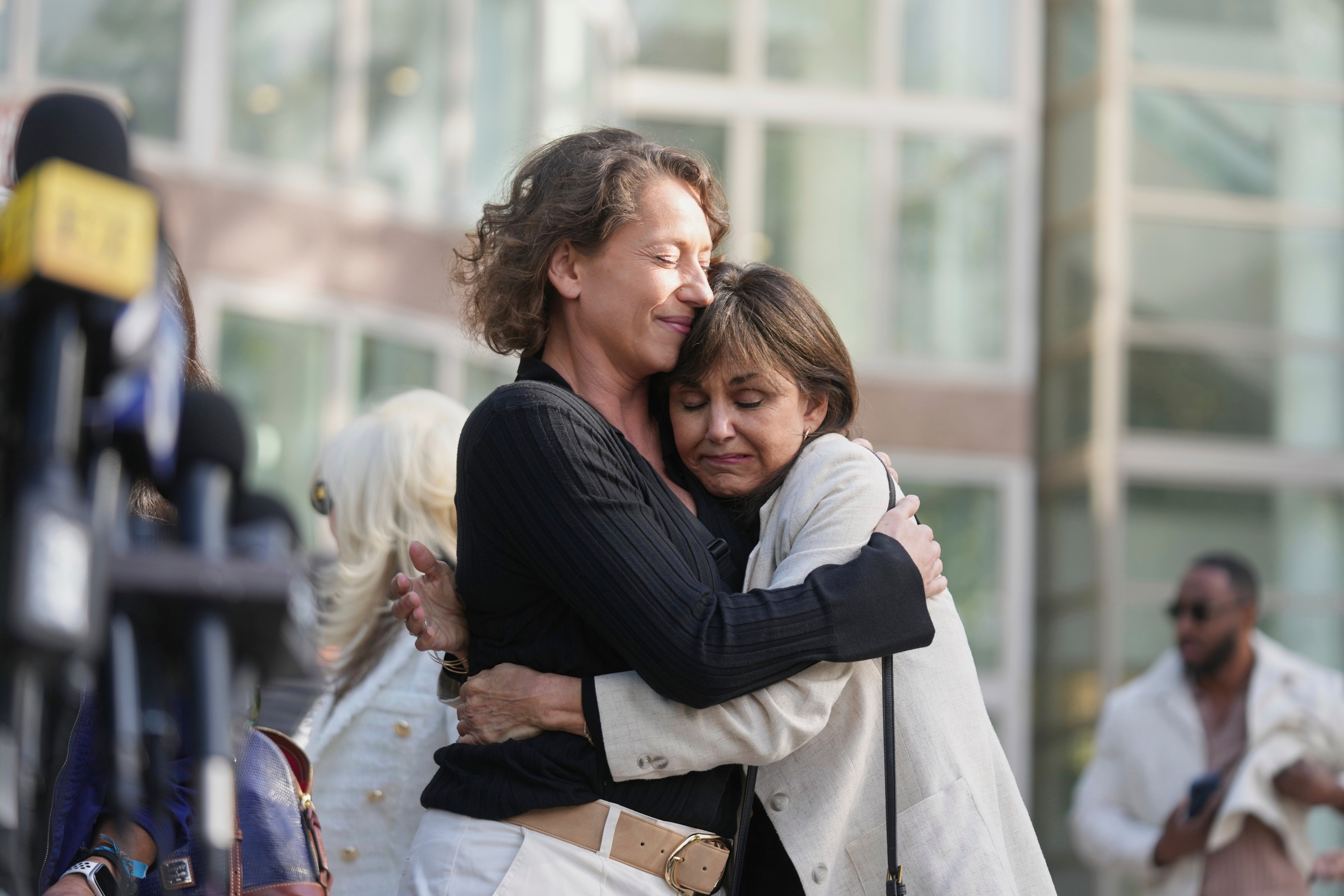 Anamaria Baralt, left, cousin of Erik and Lyle Menendez, left, gets a hug as she leaves the courthouse after the brothers' resentencing hearing Tuesday, May 13, 2025