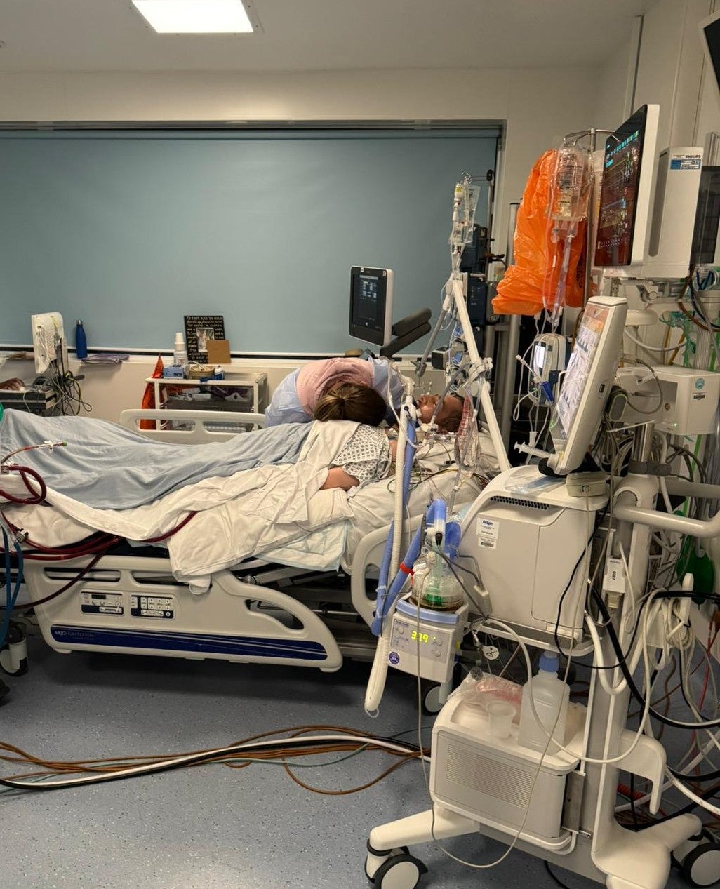 Edward Burr in hospital, with Laura by his side