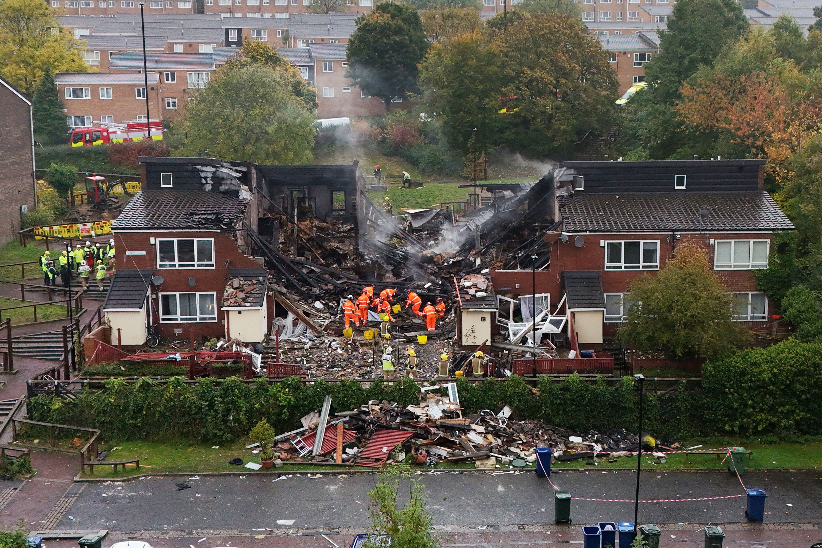 Emergency workers at the smoking ruin of the building following the blast