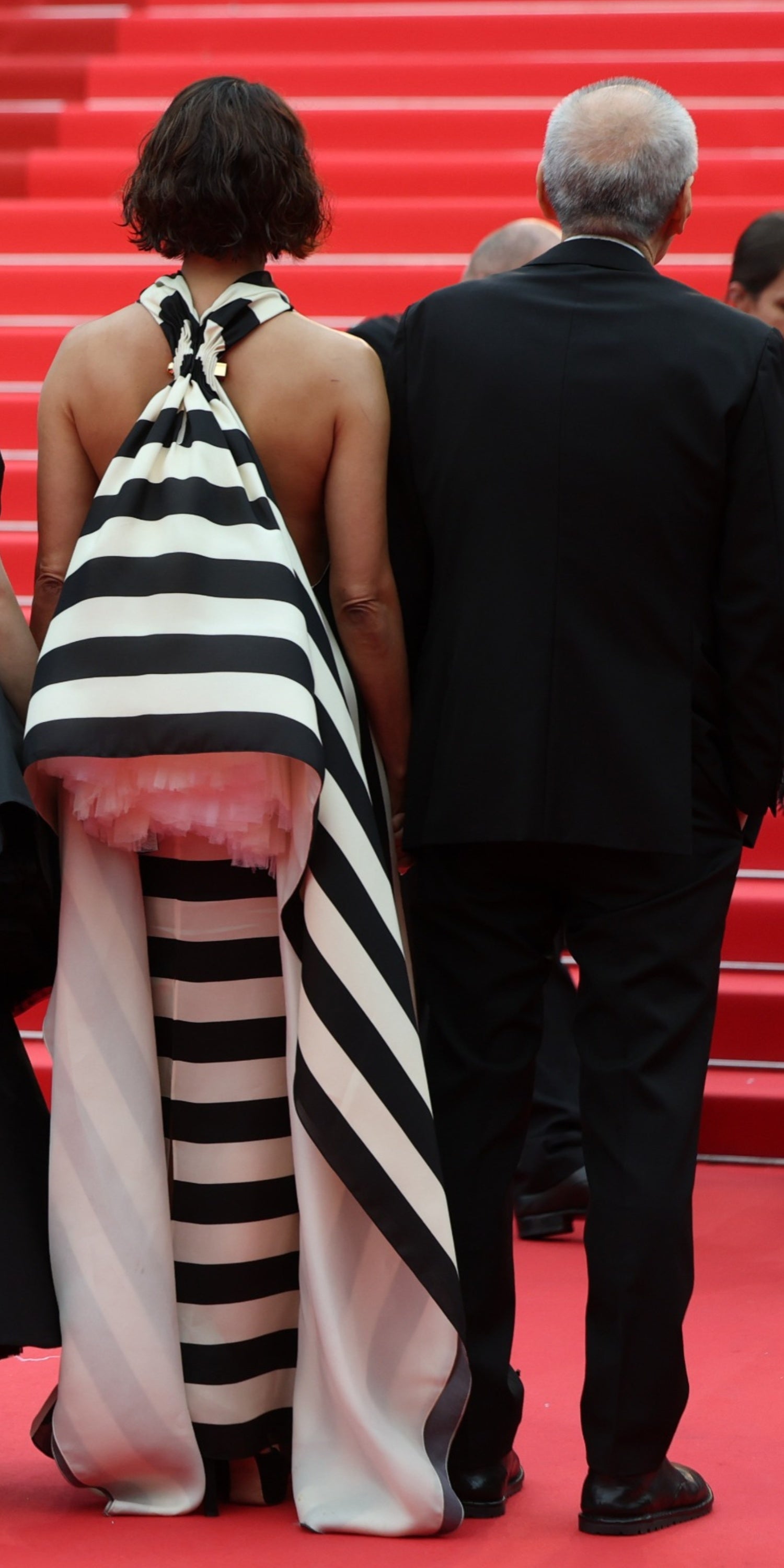 The black and white-striped dress was embellished with a random ball of pink tulle hidden under the fabric on her back, which gave the illusion she was wearing a backpack