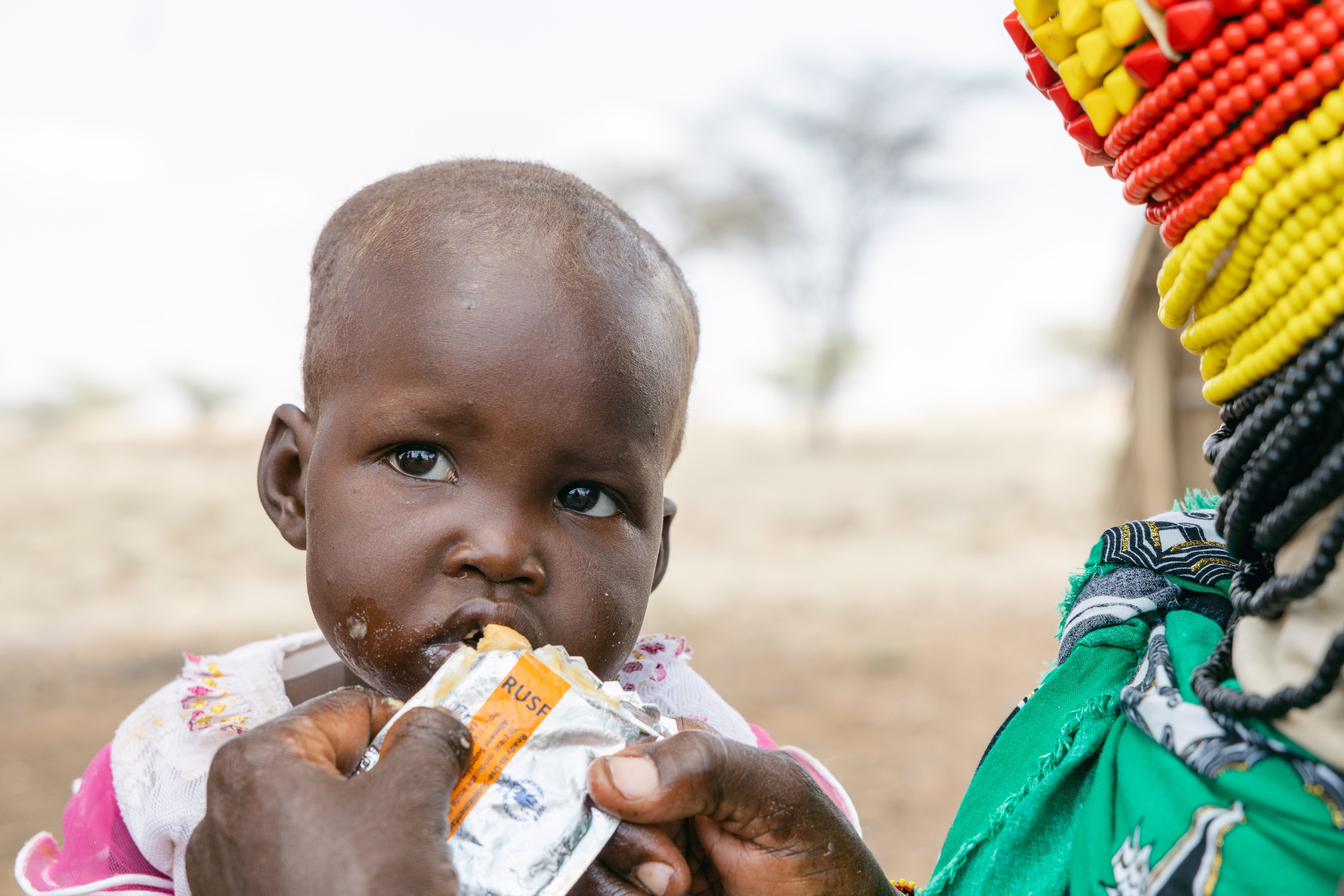 Ereng, 18 months, eating the fortified peanut paste she has been given as part of her malnutrition treatment