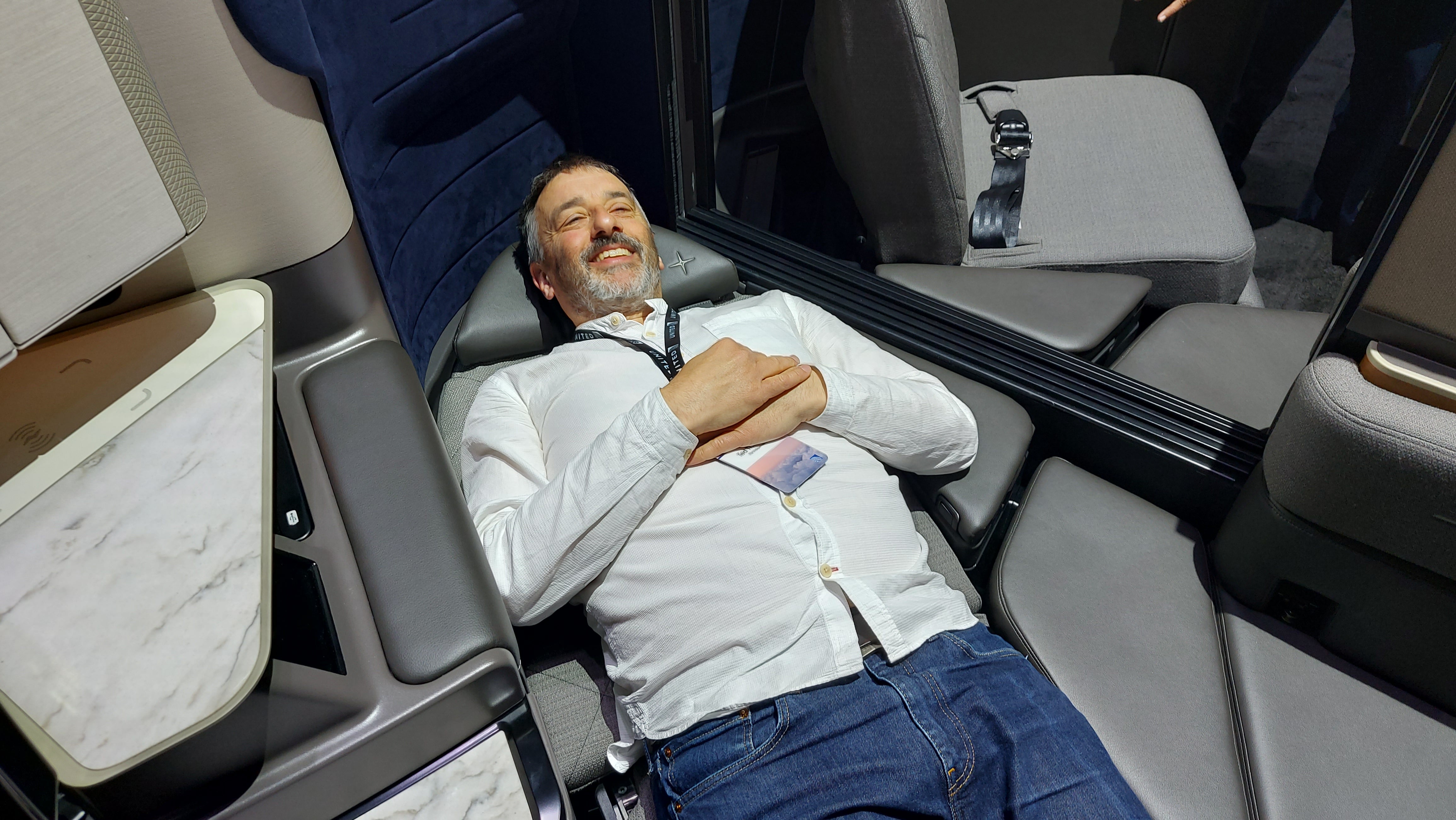 The Independent's Ted Thornhill tries out United Airlines' new Dreamliner seats at a launch event in Brooklyn. He's pictured above in a working version of the new Polaris Studio business-class seat, which can become a double bed with a mattress topper