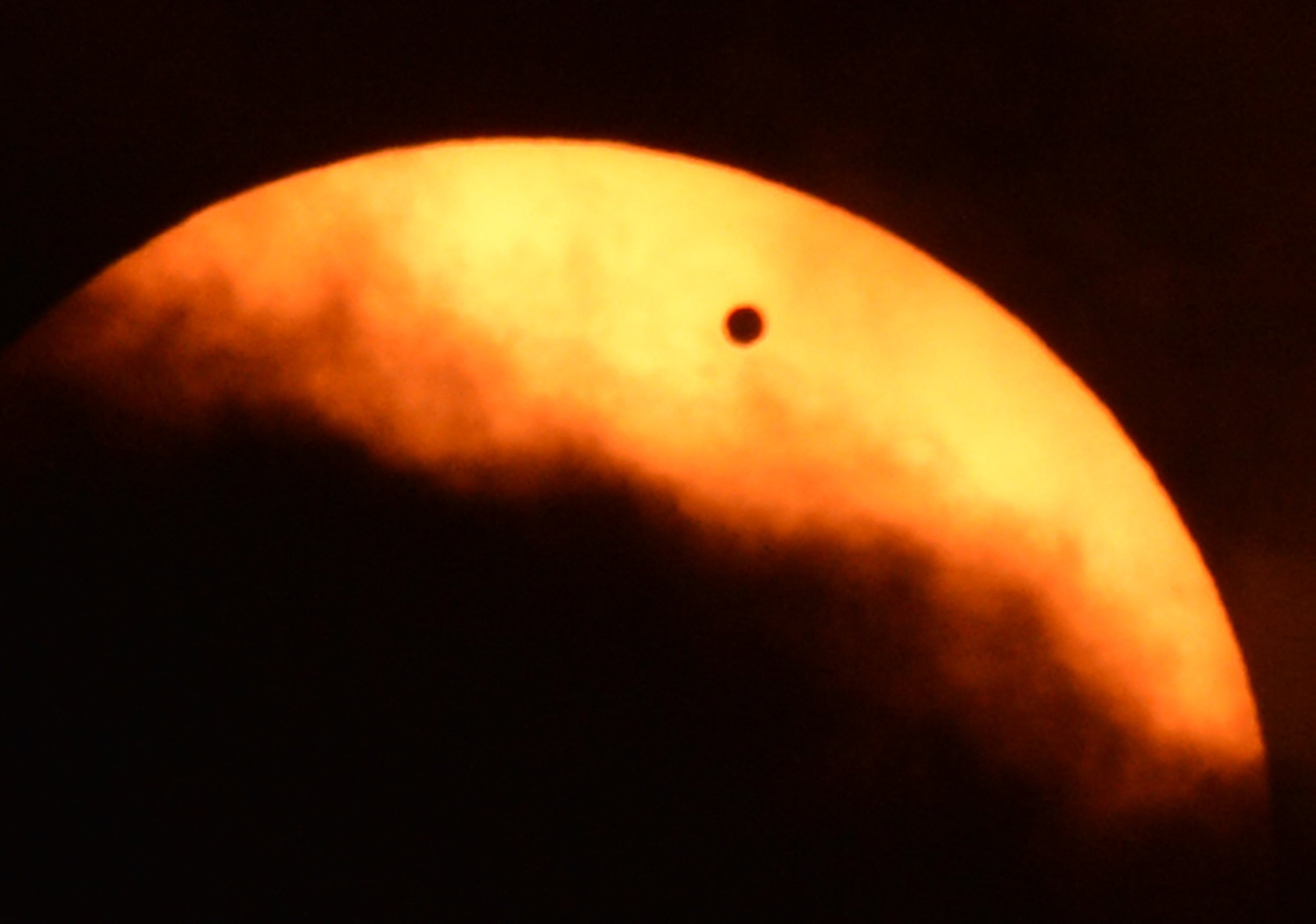 Clouds partially obscure the sun during the transit of Venus June 5, 2012 as seen from Riverside Park on the west side of Manhattan in New York