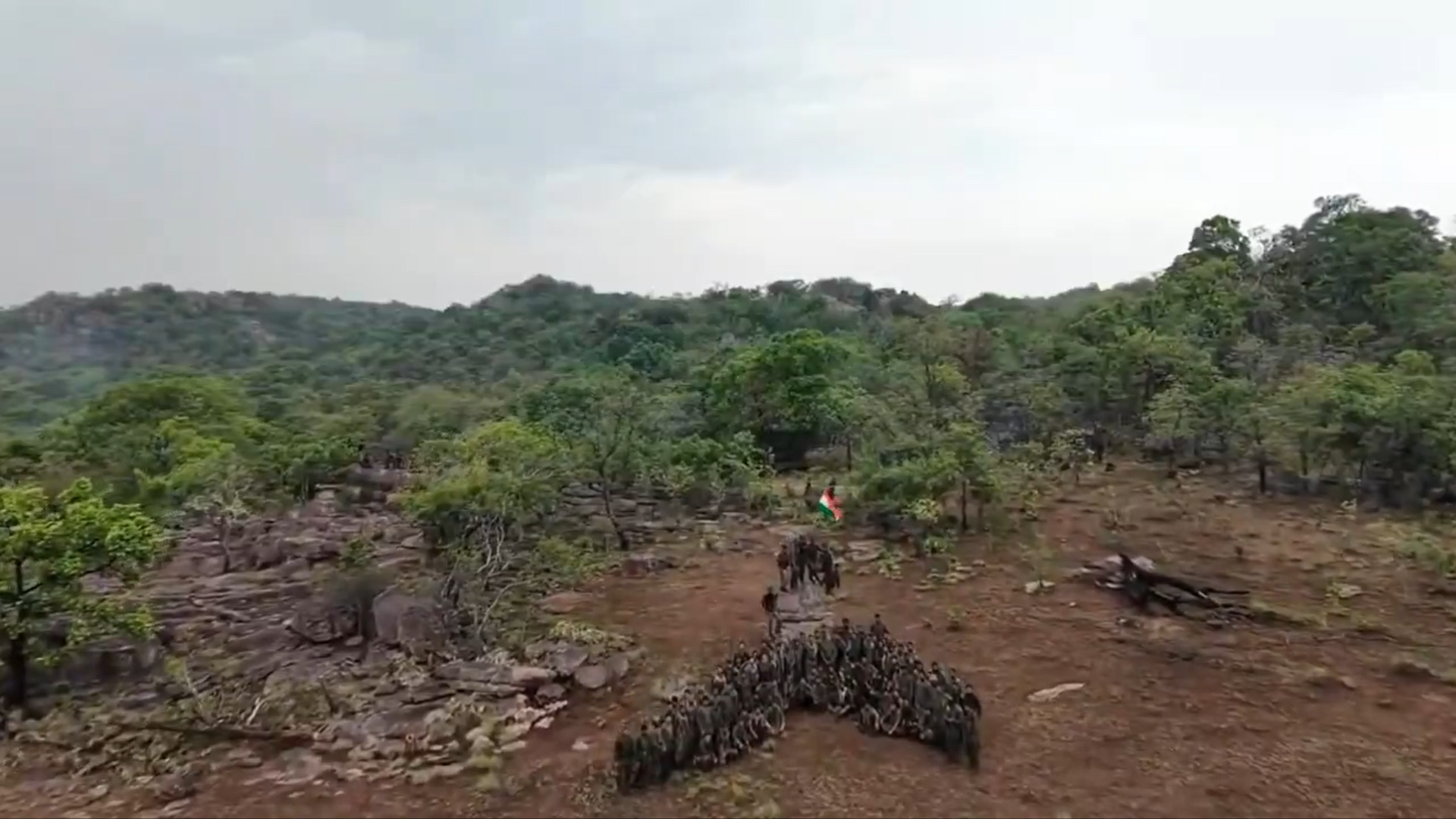 Security forces hoist a flag on a mountaintop following an operation against the Maoists in central India