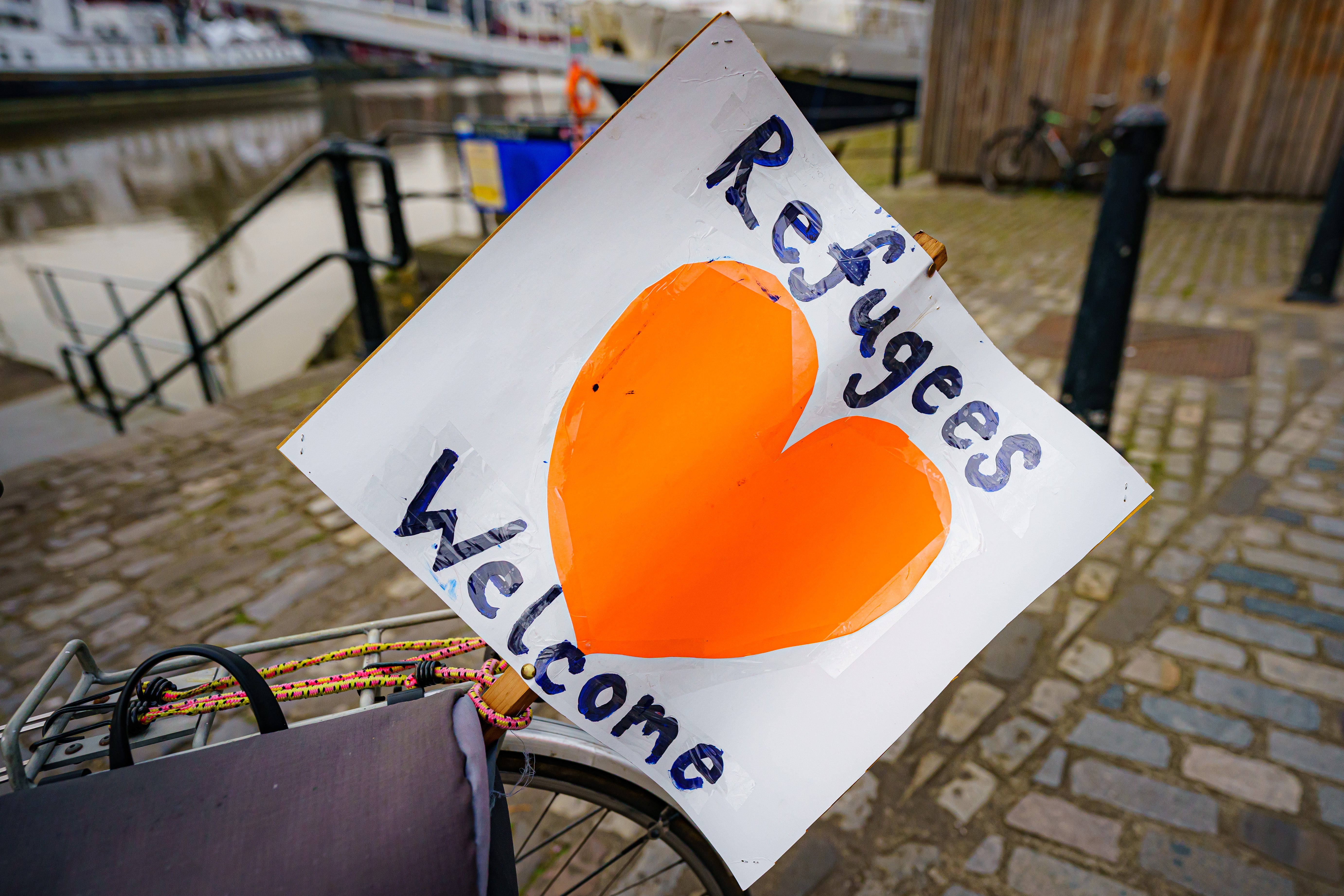 A 'refugees welcome' banner attached to a bicycle by a small flotilla of boats leaving Bristol harbour in support of Ukrainian refugees