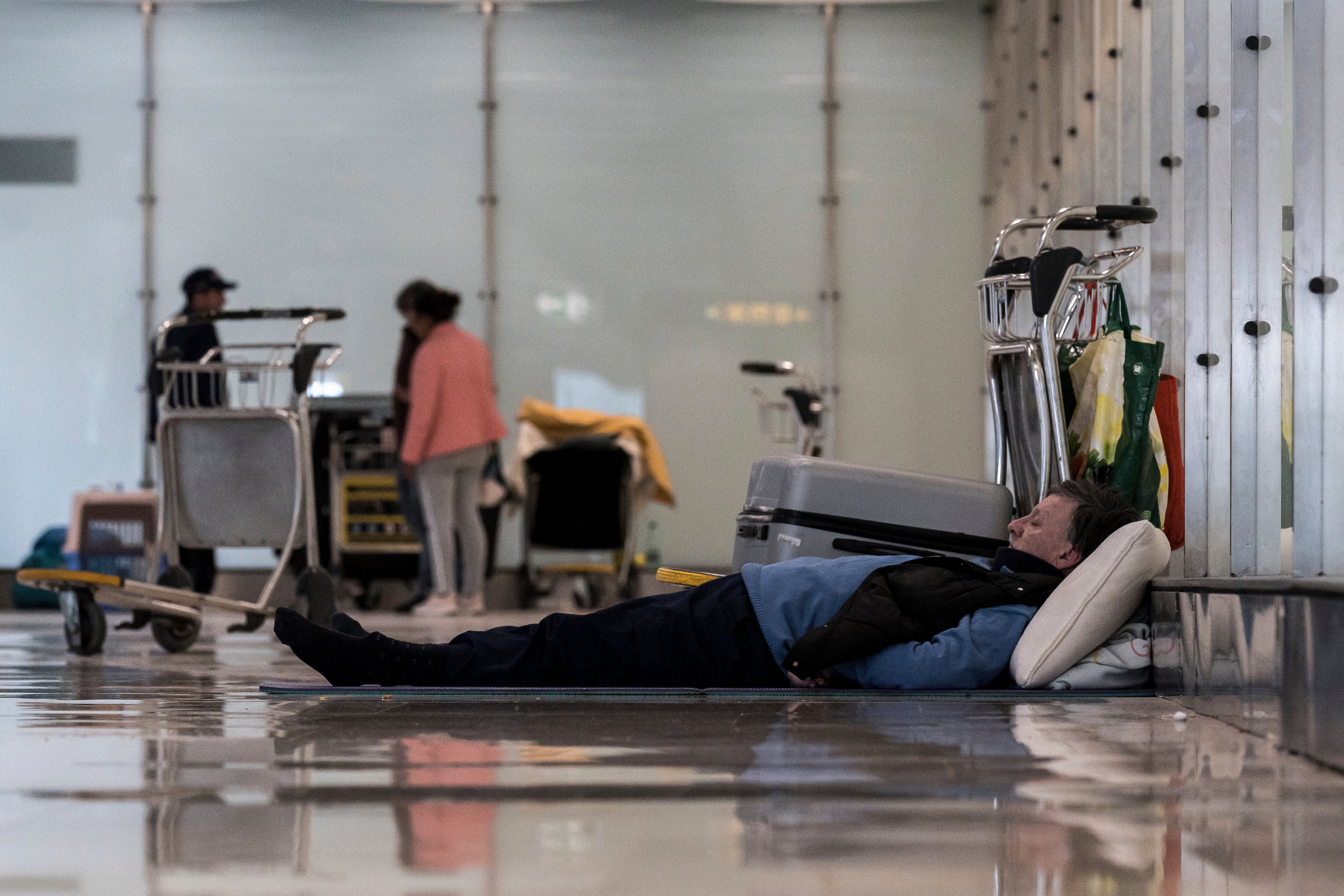 A person rests in terminal 4 of Barajas Airport