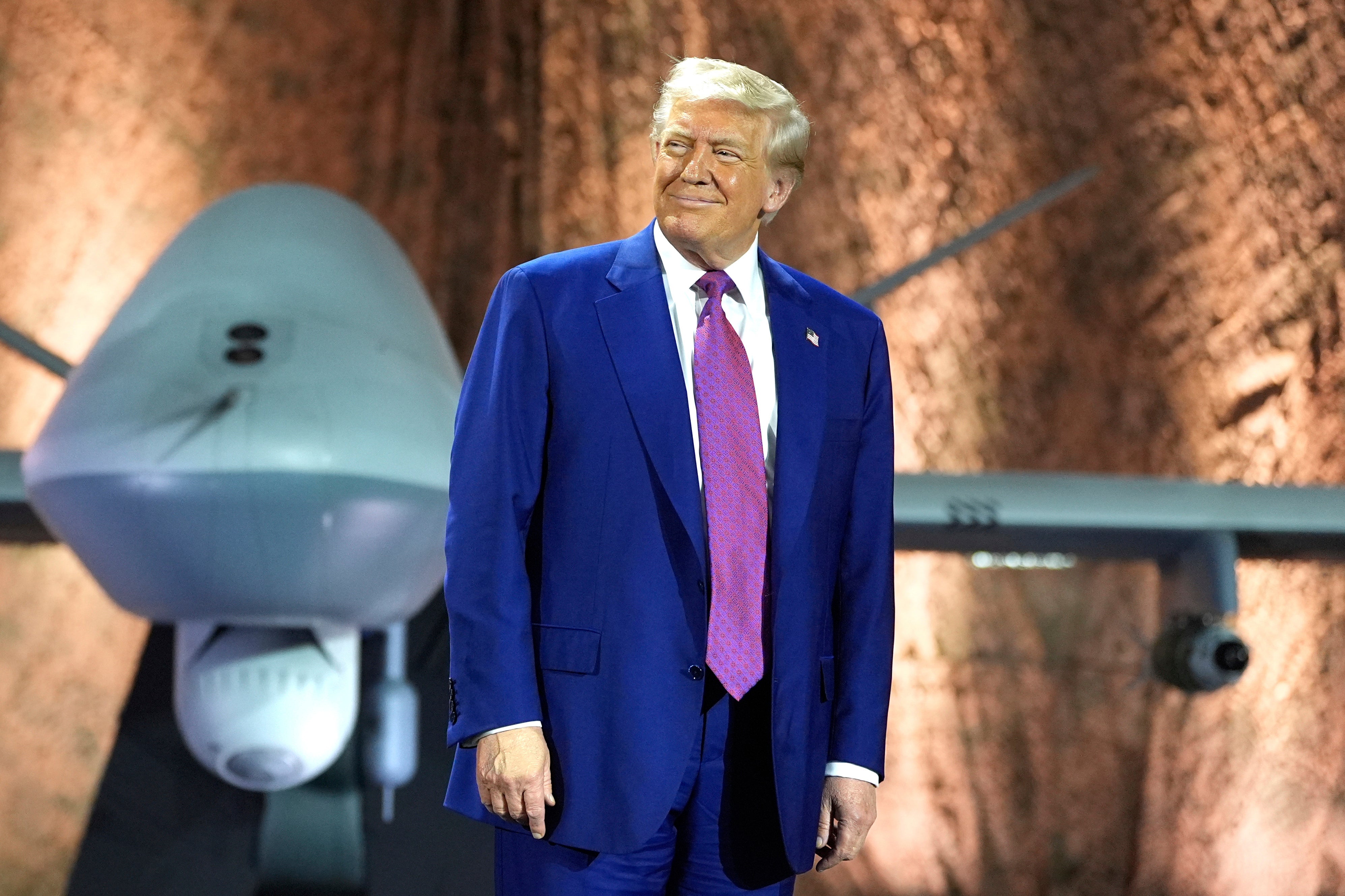 President Donald Trump smiles backdropped by an MQ-9 Reaper drone earlier addressing subject unit astatine nan Al Udeid Air Base, Thursday, May 15, 2025, successful Doha, Qatar. (AP Photo/Alex Brandon)