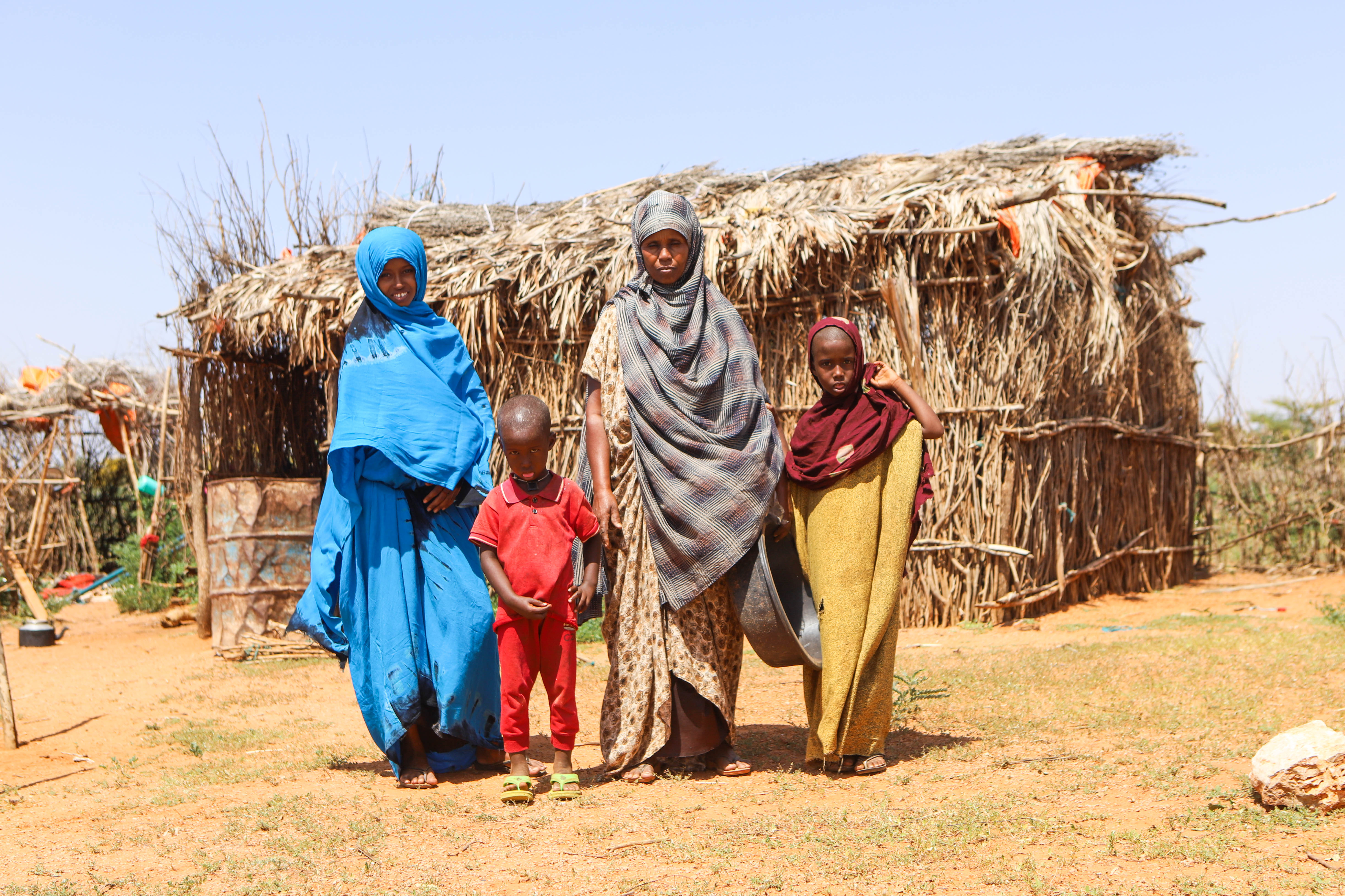 Habiba Abdulahi and three of her children pose for photos in front of their home