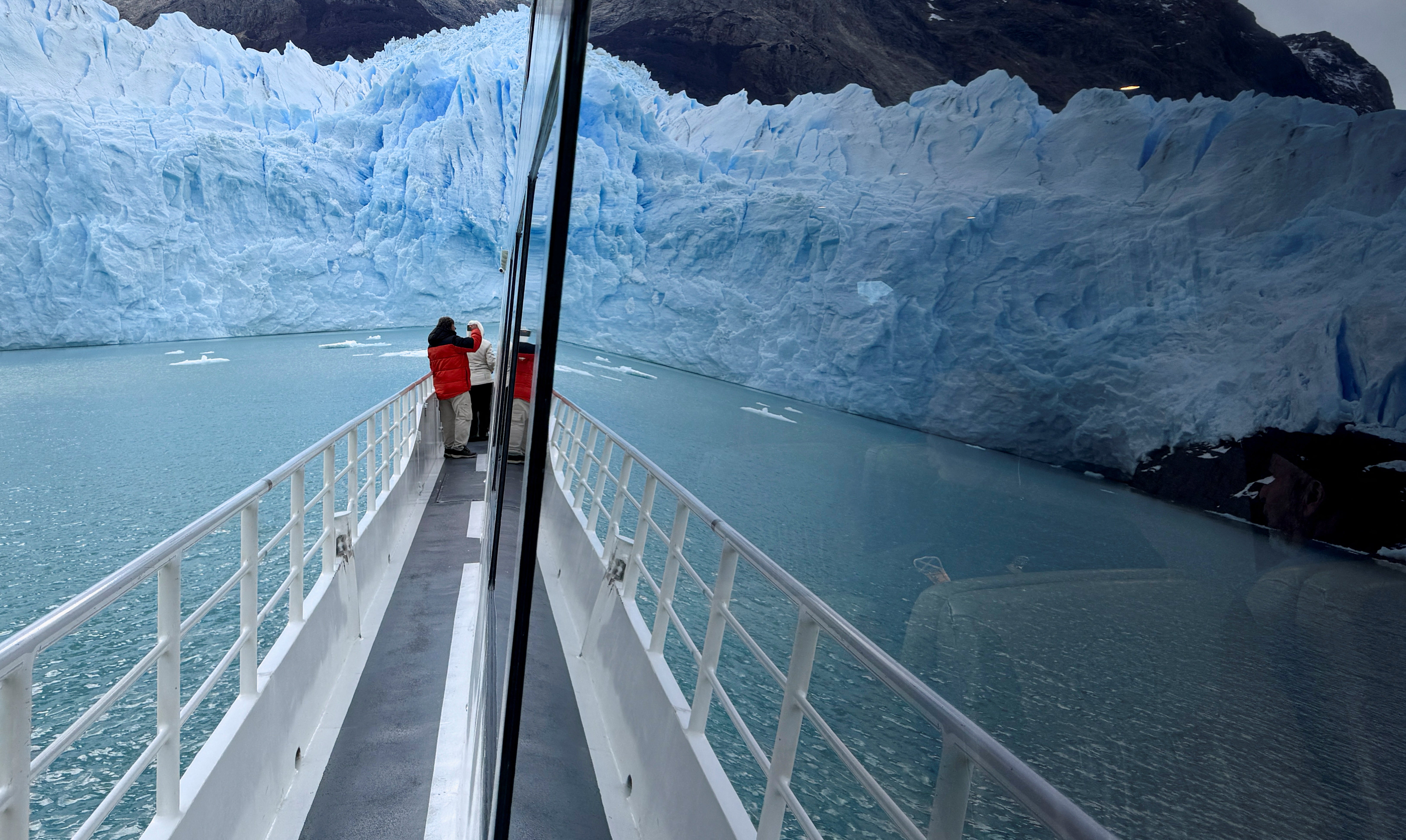 The Perito Moreno glacier is seen reflected in the window of a tourist boat, near the city of El Calafate in the Patagonian province of Santa Cruz, Argentina