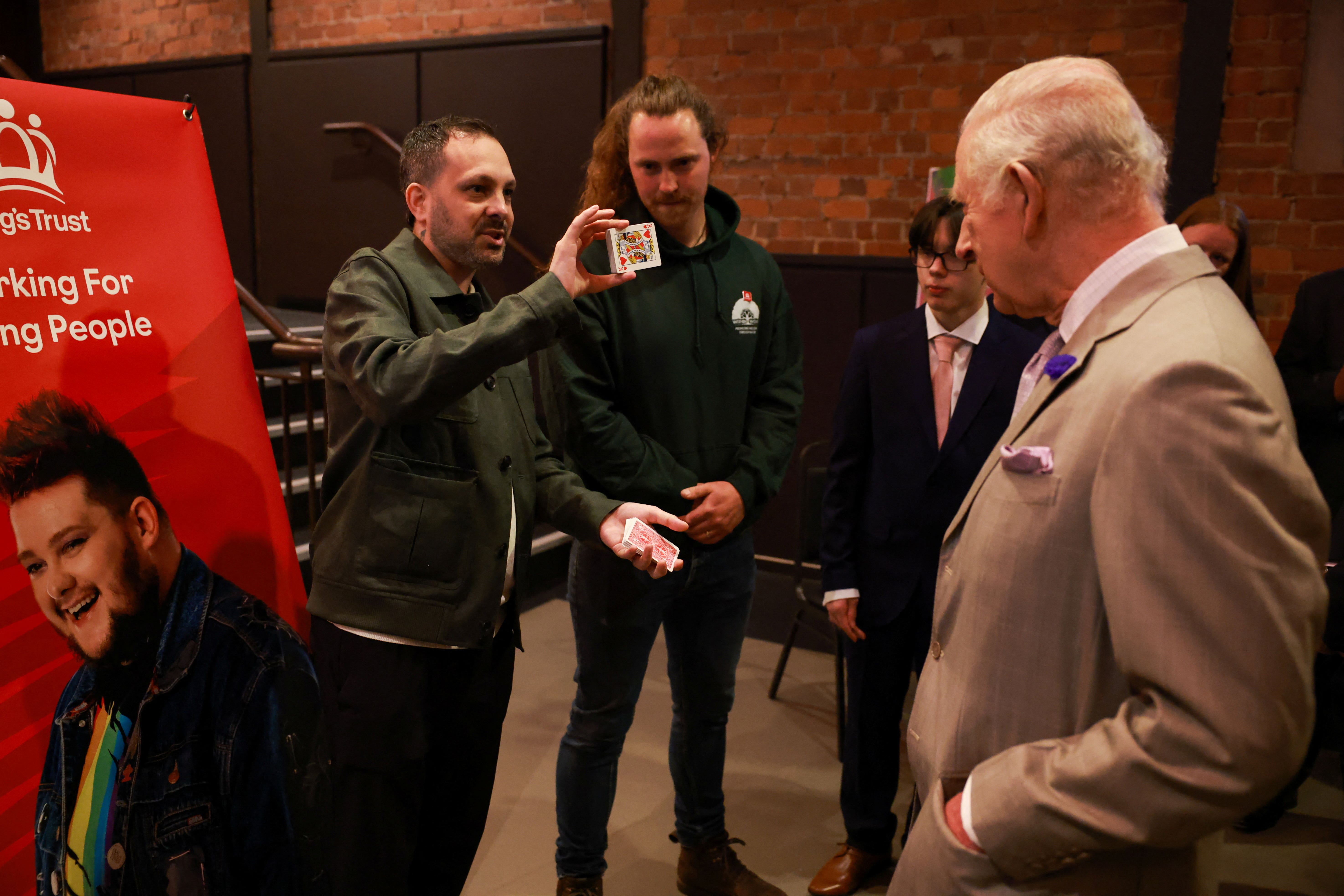 The King watches as magician Steven Frayne performs a trick (Phil Noble/PA)