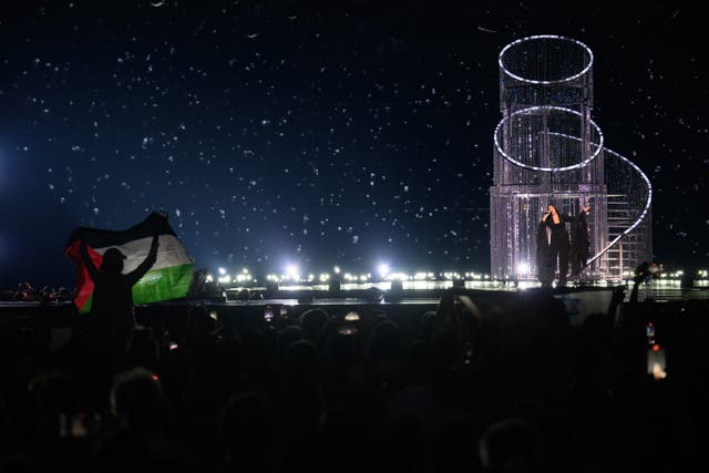 <p>Protestors wave the Palestinian flag (L) as Yuval Raphael representing Israel performs during the rehearsal ahead of Semi Final Round 2 of the 69th Eurovision Song Contest Opening Ceremony </p>