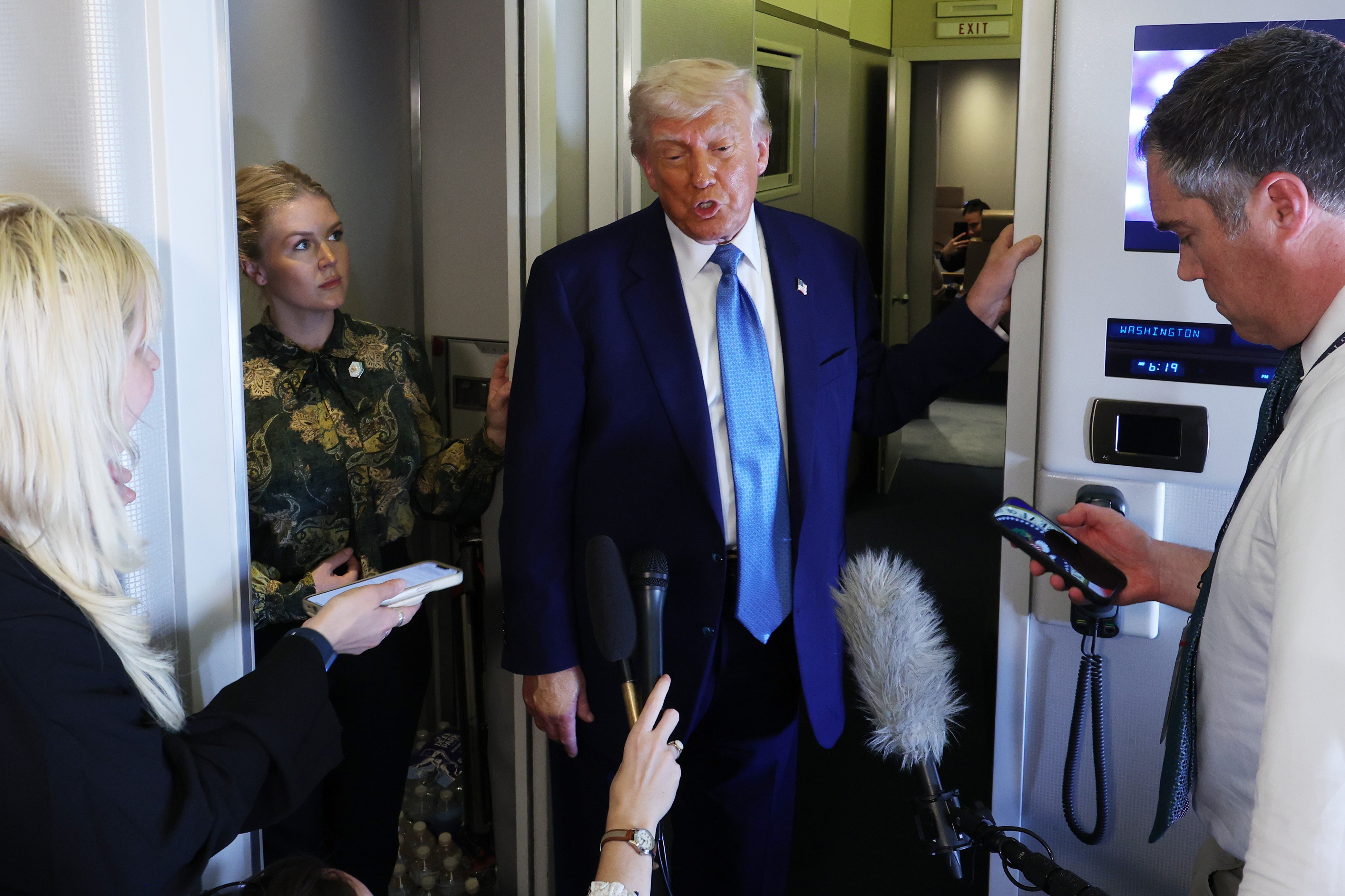Donald Trump speaks to reporters on Air Force One as he returns to the US from the Middle East