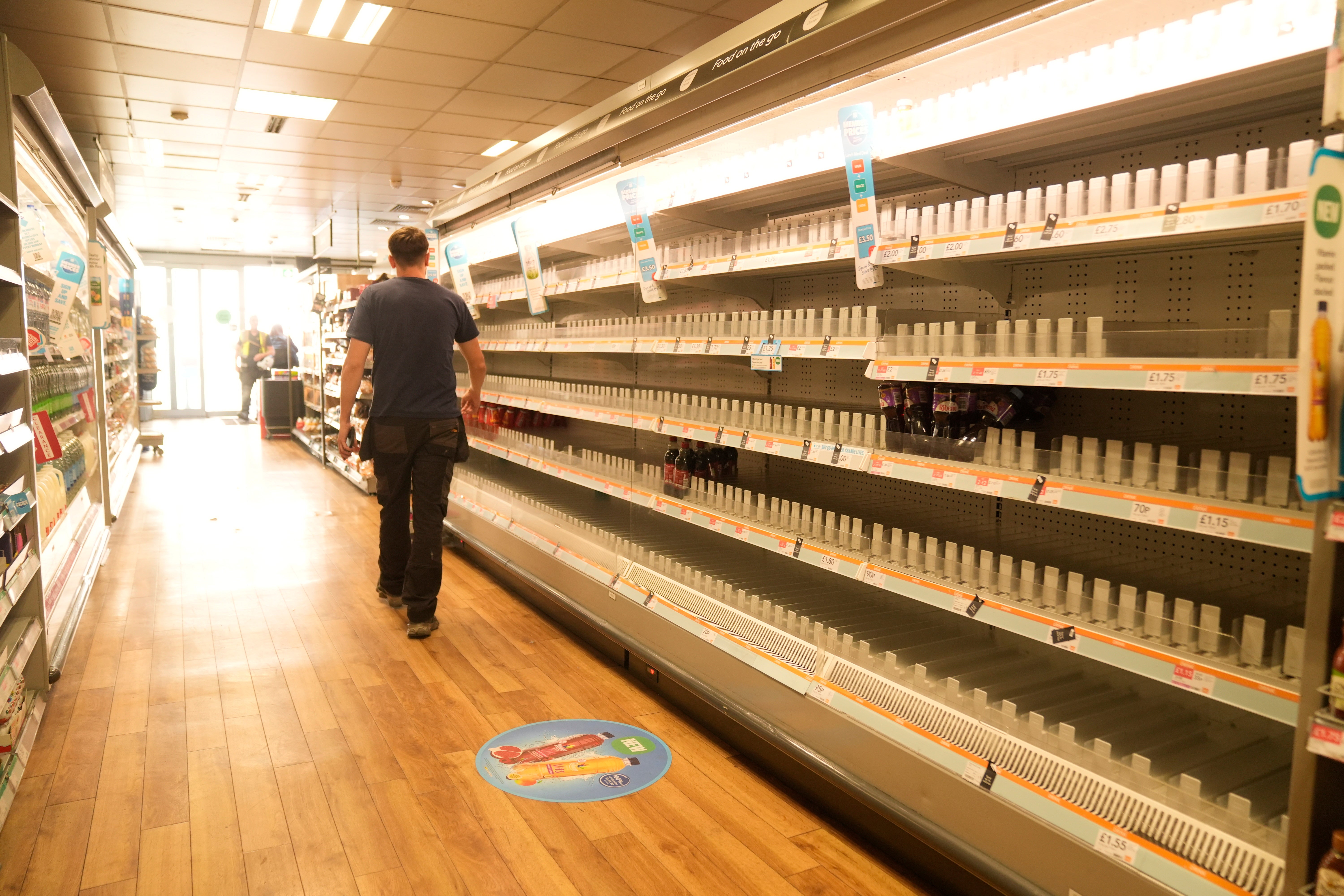 A man walks past empty shelves in a branch of the Co-op in Manchester last week