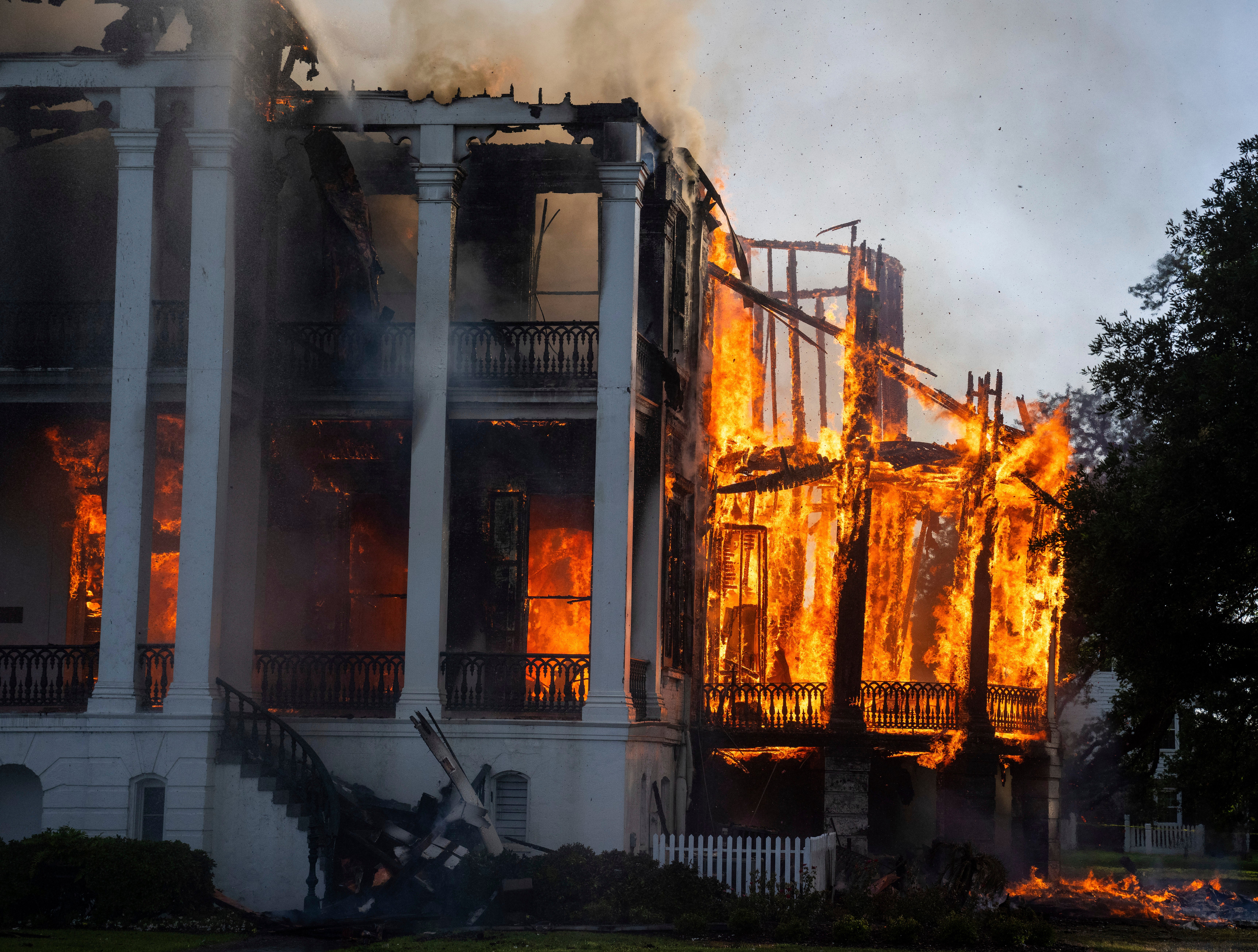 The north wing of the Nottoway Plantation in Louisiana starts to collapse as crews battle the fire.