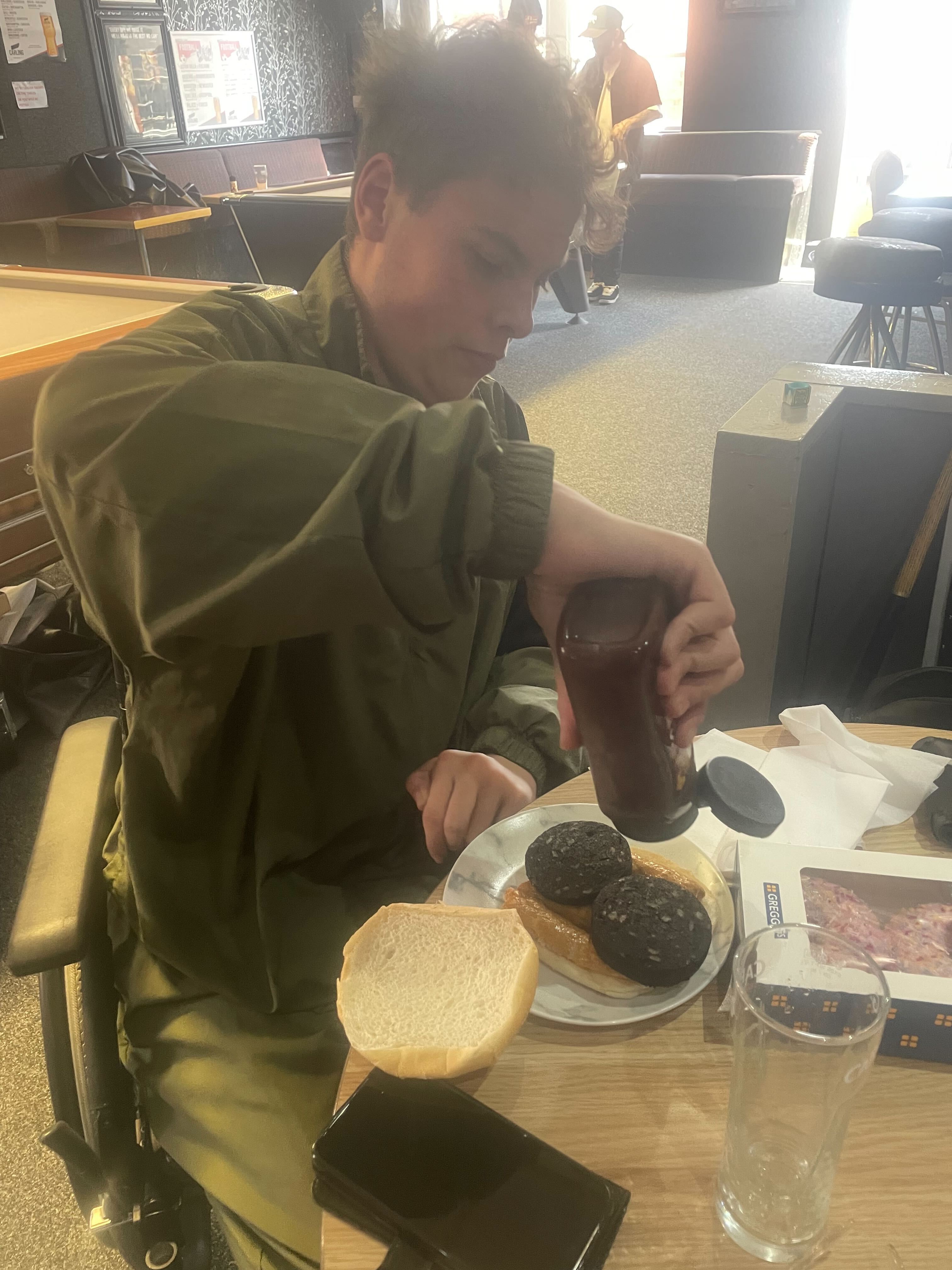 Samuel Ackerley, 20, tucks into a double black pudding and sausage bap