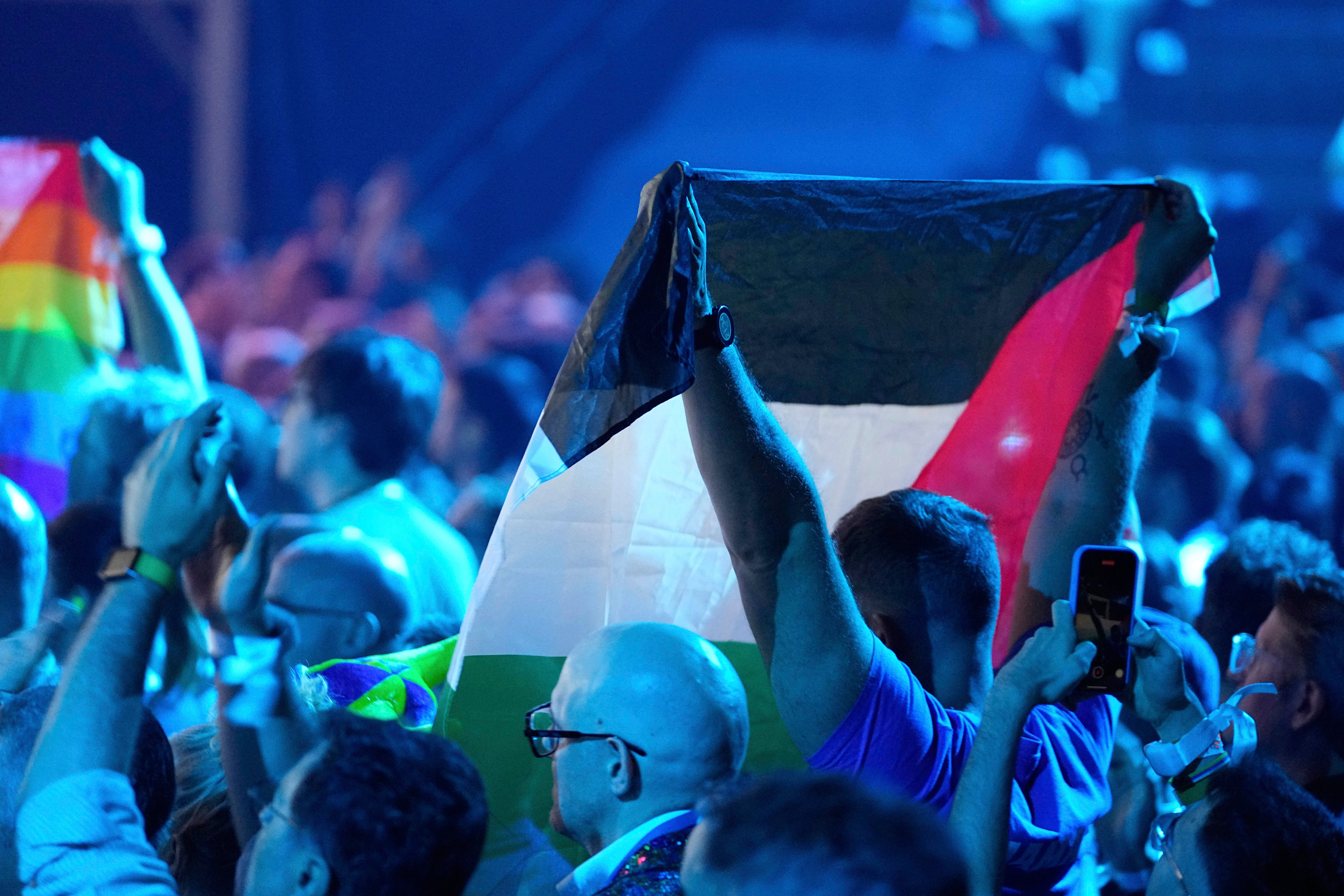 A Palestinian flag is held up in the audience as Yuval Raphael from Israel performs during a dress rehearsal on Friday (Martin Meissner/AP/PA)