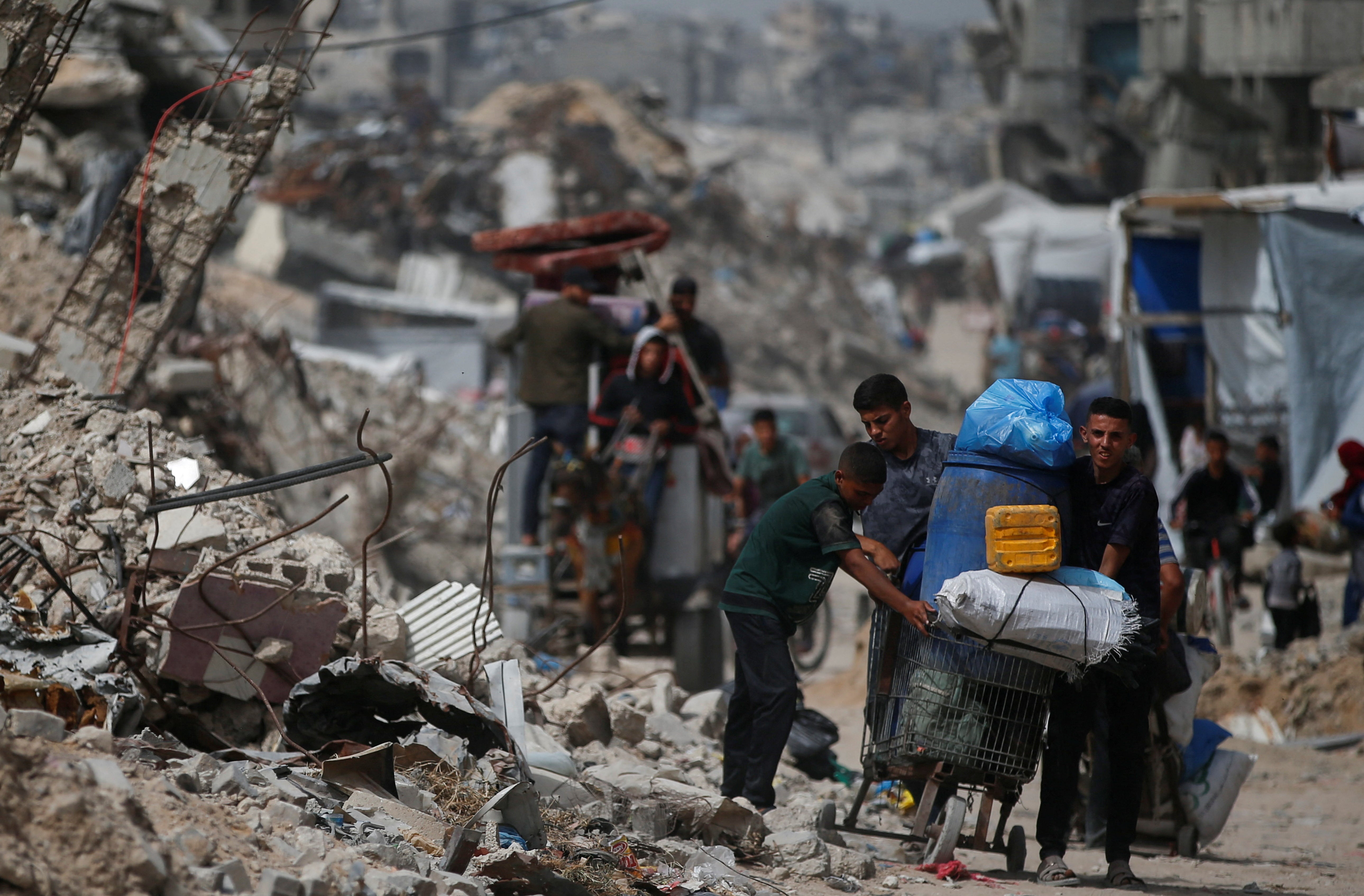 Palestinians make their way with belongings as they flee their homes, after Saturday’s Israeli air strikes, in the northern Gaza Strip