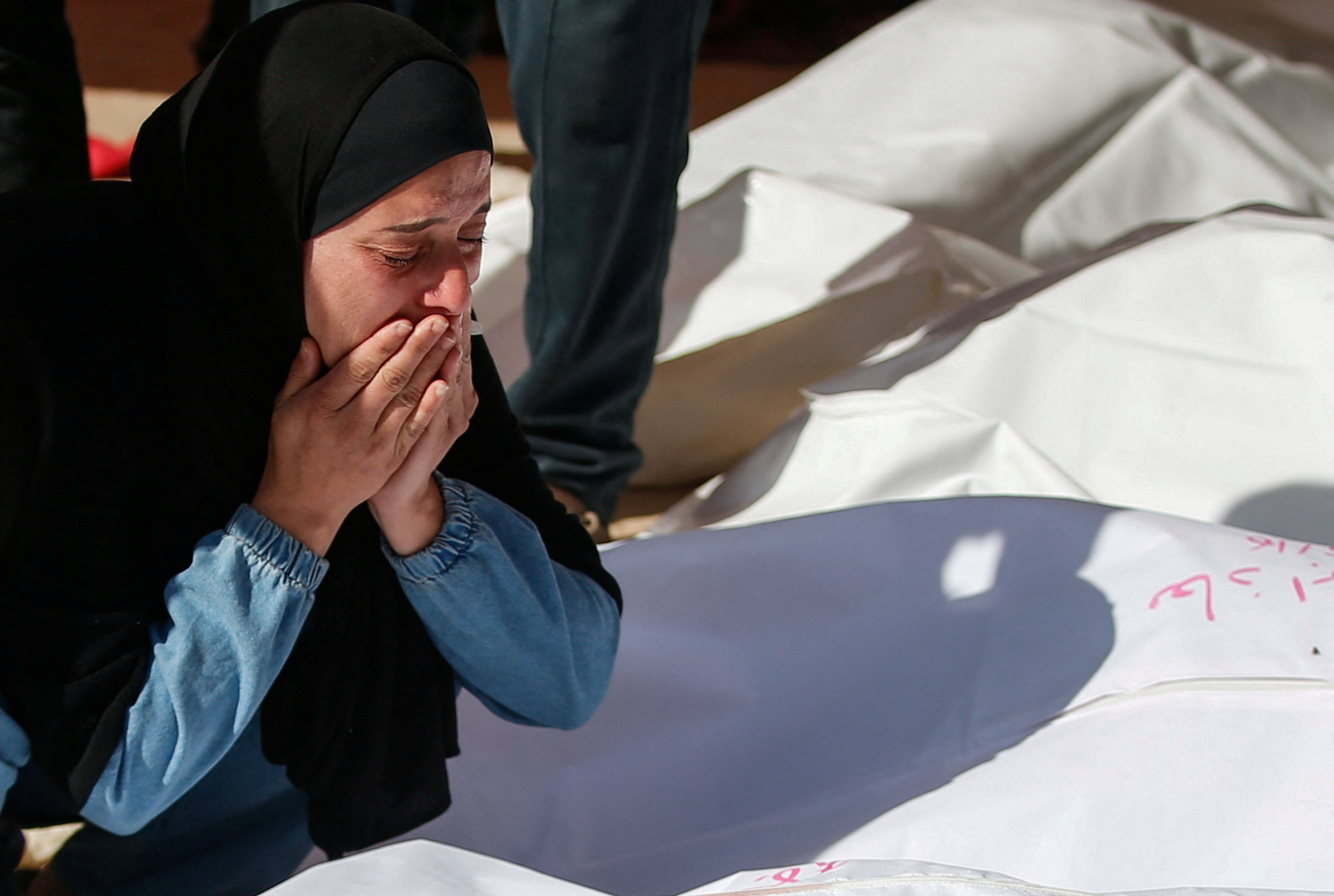 Mourners react during the funeral of Palestinians killed in Israeli strikes, in Beit Lahia