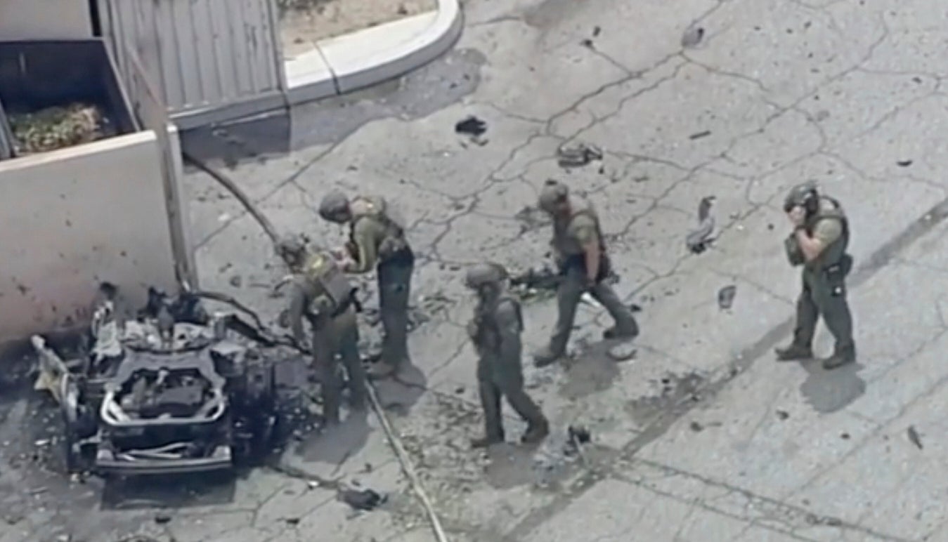 Law enforcement investigate a vehicle after an explosion on Saturday, May 17, 2025 in Palm Springs, California