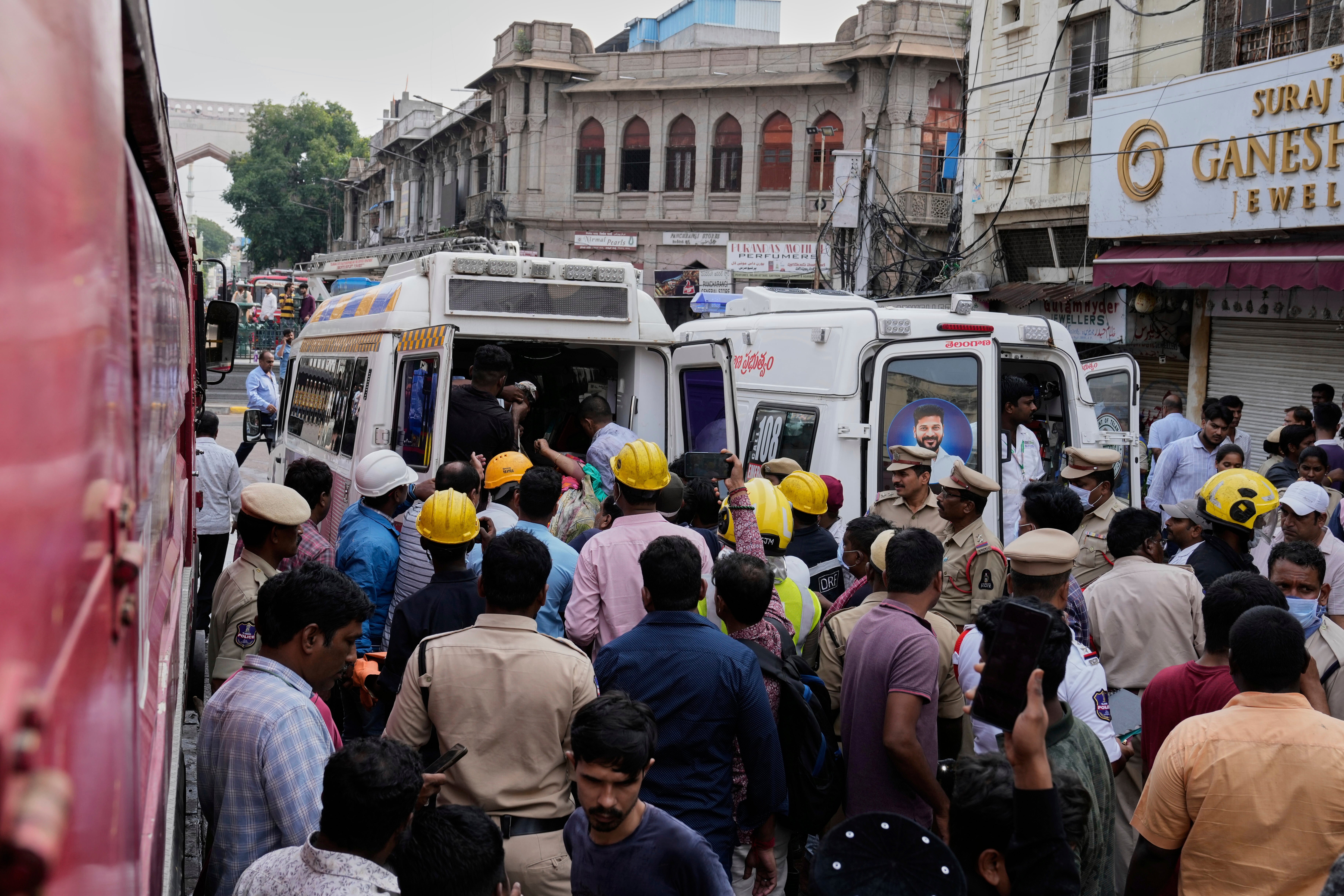 Fire officials rescue an injured person from a building after it caught fire in Hyderabad
