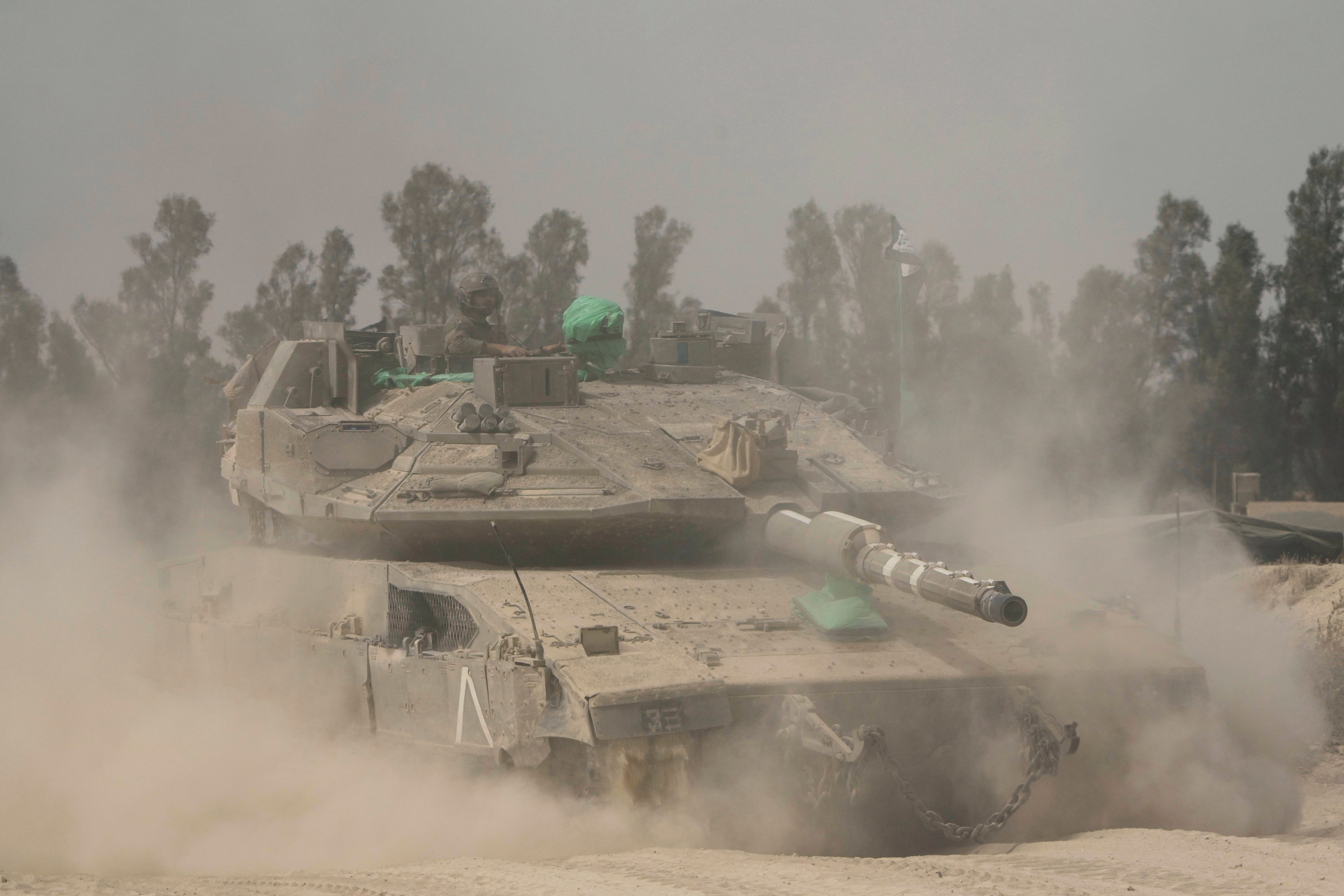 Israeli soldiers move tanks around a staging area near the border with the Gaza Strip, in southern Israel, on Sunday