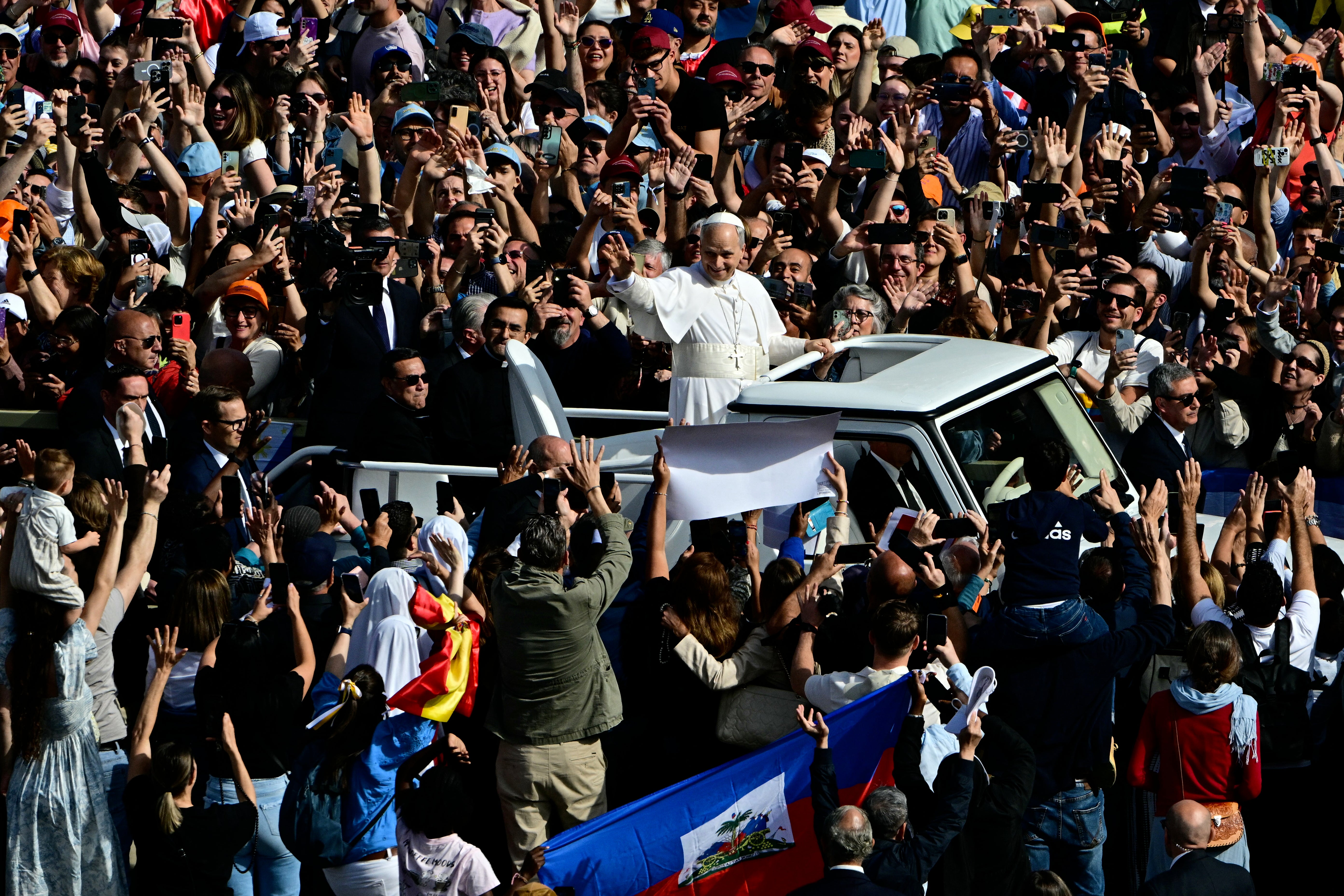 The pontiff greets the crowd from the popemobile before the mass