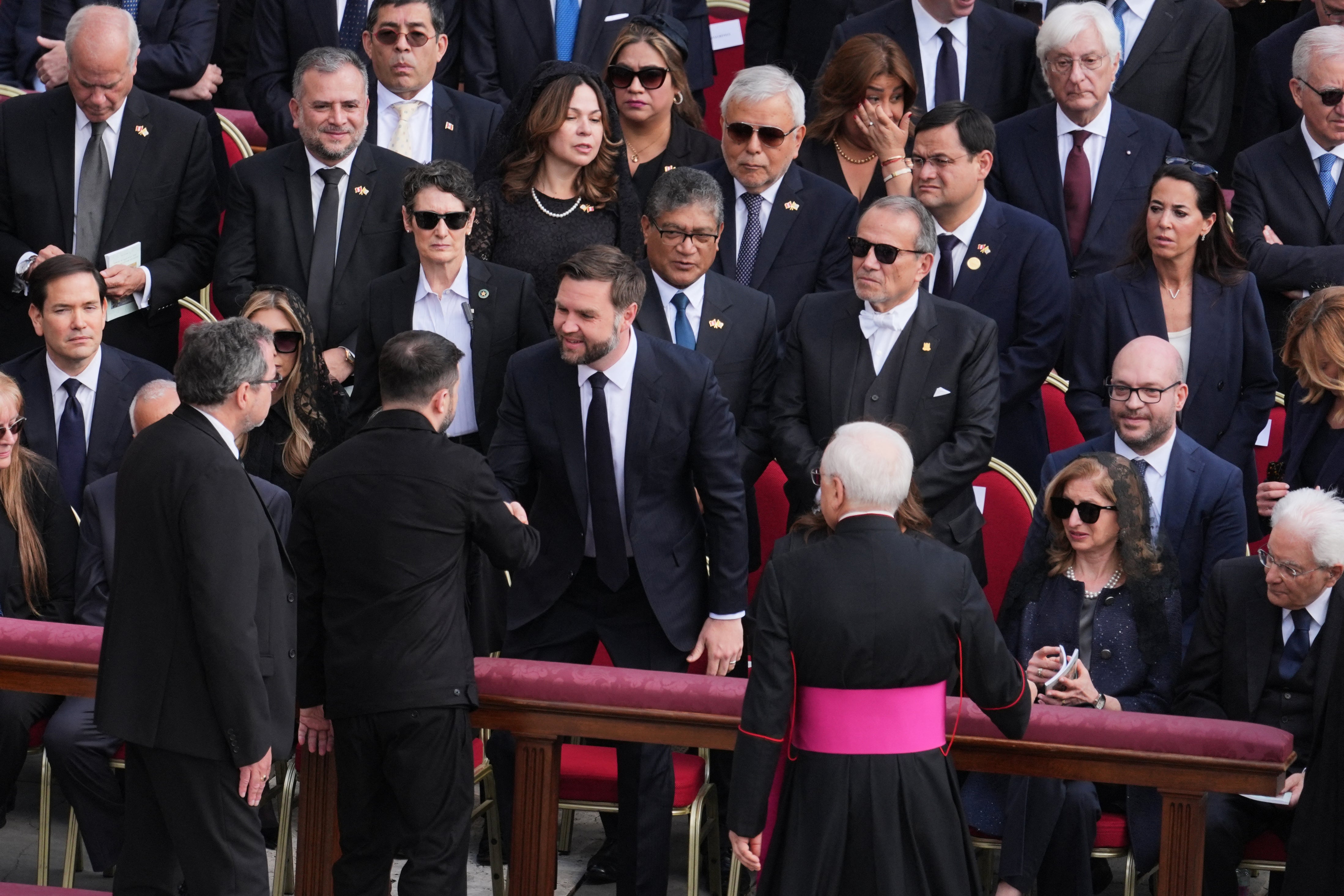 US Vice President JD Vance (C) shakes hands with Ukraine's President Volodymyr Zelensky as they arrive to attend a Holy Mass for the Beginning of the Pontificate of Pope Leo XIV