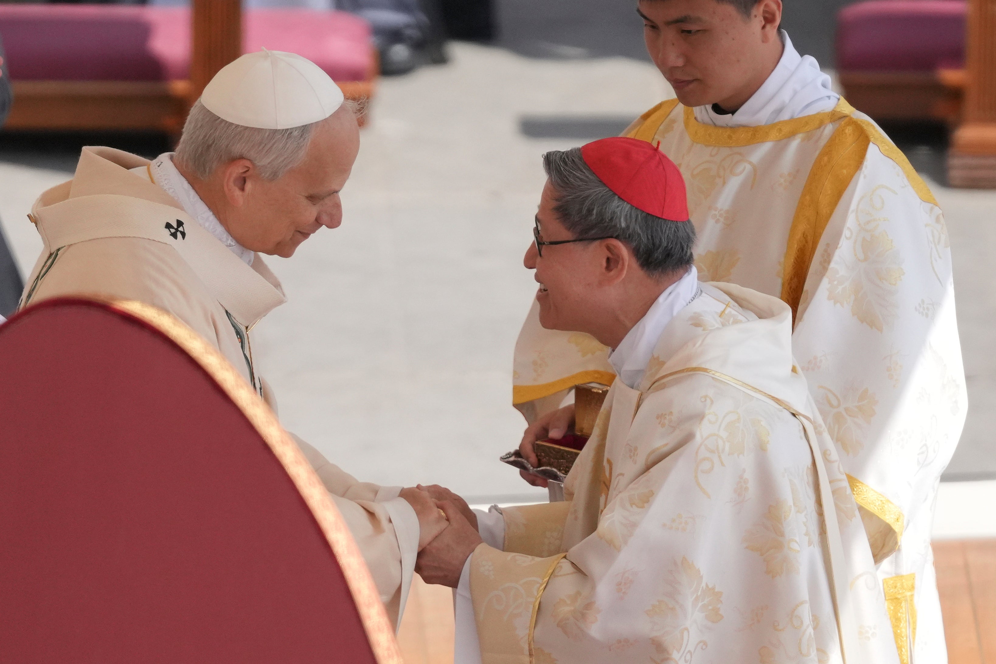 Pope Leo holds hands after receiving the fisherman’s ring, a symbol of the papacy, from Cardinal Luis Antonio Tagle, one of the papabile during the conclave