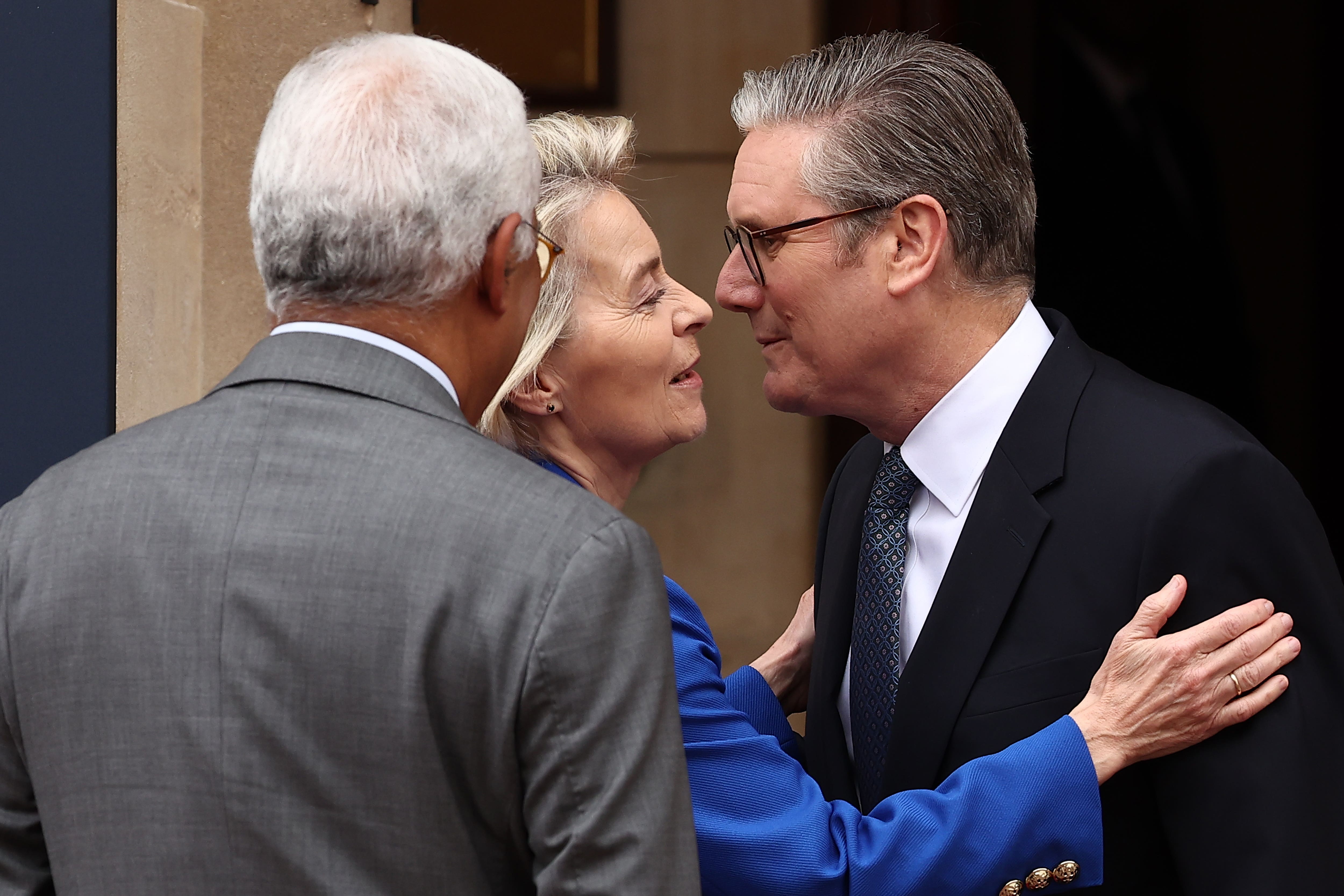 Prime Minister Sir Keir Starmer (right) kisses European Commission President Ursula von der Leyen as he greets her and European Council President Antonio Costa at the UK-EU Summit at Lancaster House, in central London (Henry Nicholls/PA)