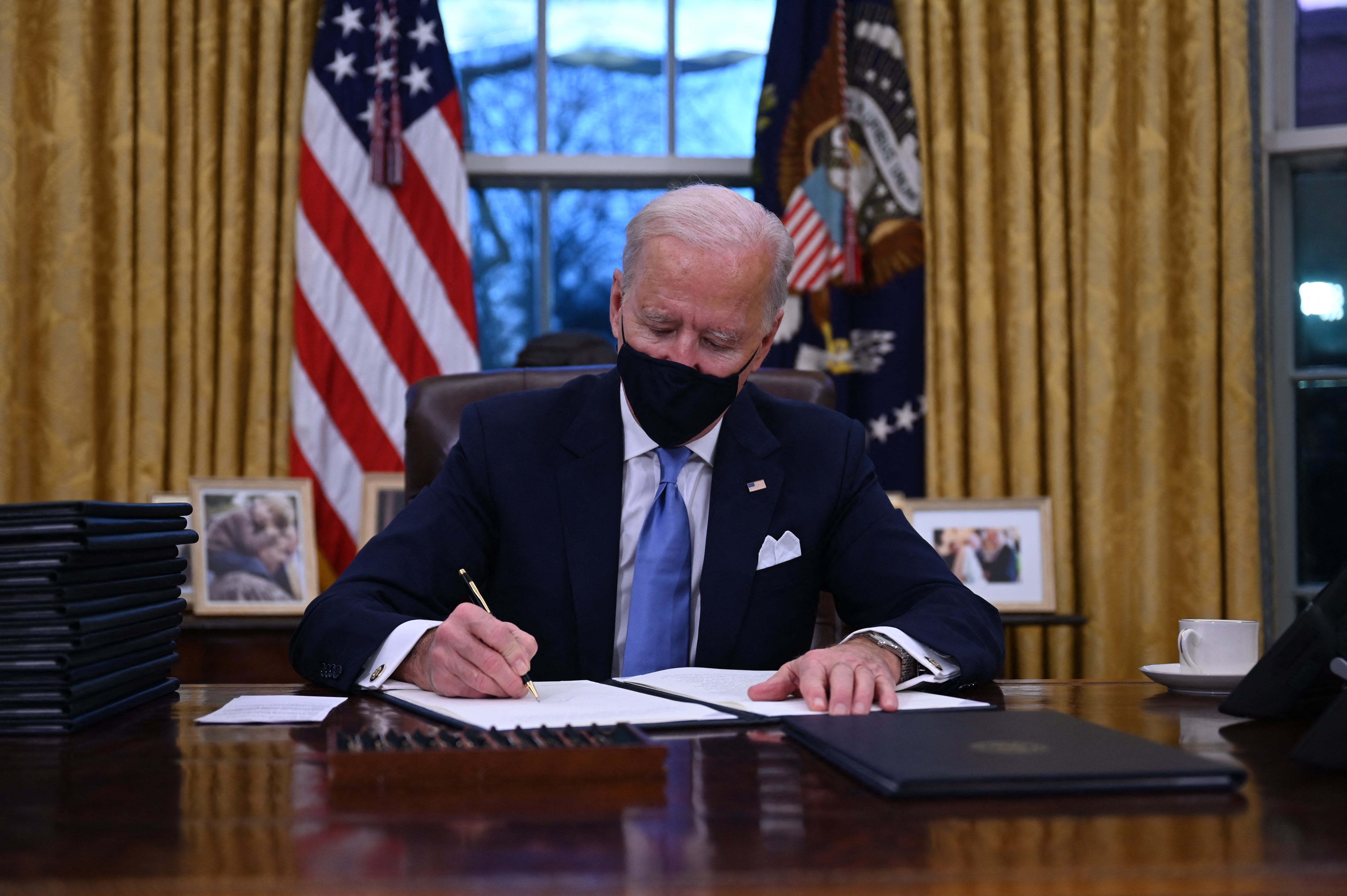 Joe Biden signing a series of orders on January 20, 2021, shortly after being sworn in