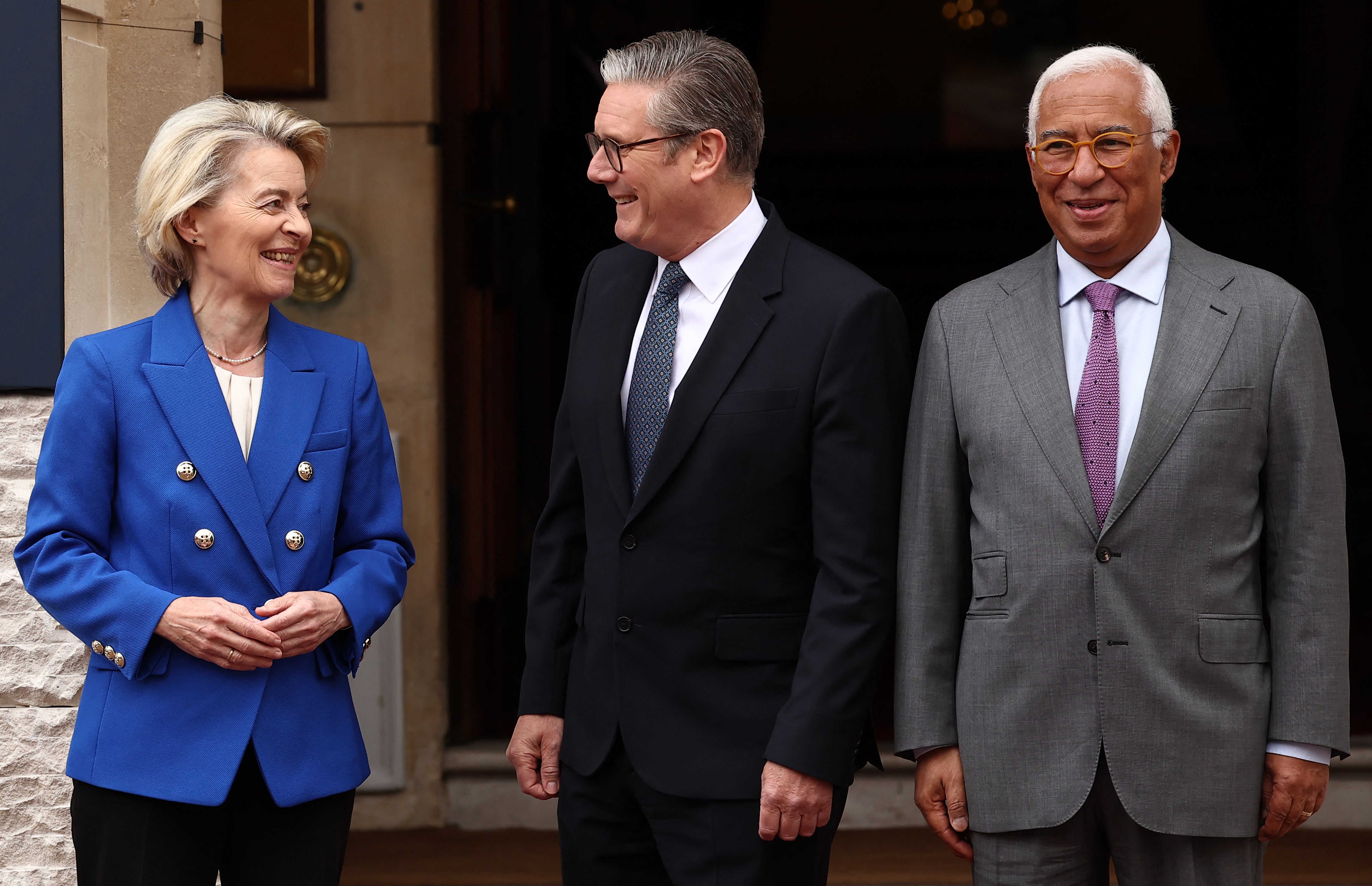 Britain's Prime Minister Keir Starmer (C) and European Commission President Ursula von der Leyen (L) react as they pose with European Council President Antonio Costa, ahead of the UK-EU Summit at Lancaster House in London on May 19, 2025