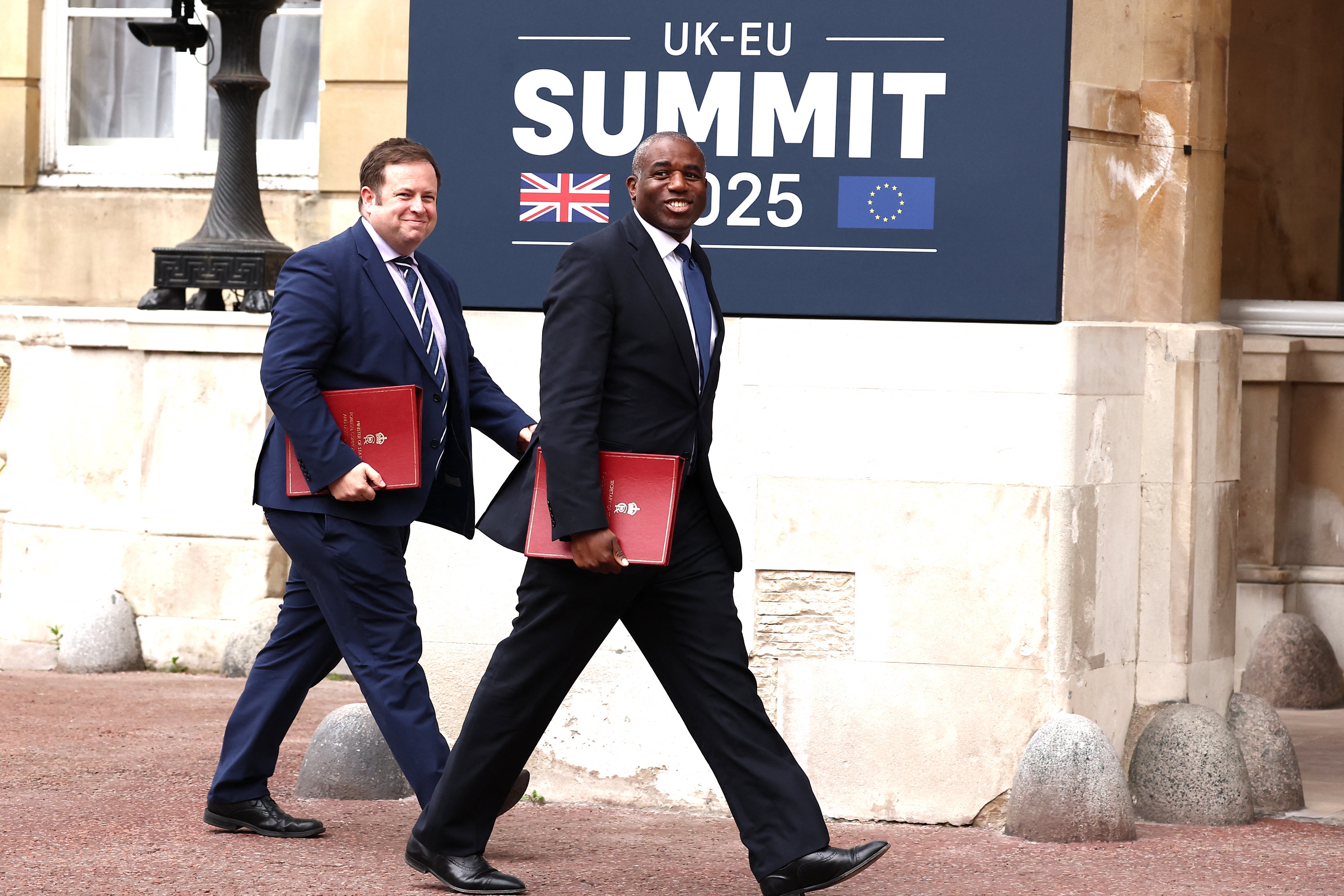Foreign secretary David Lammy, right, arrives equipped with a burgundy folder