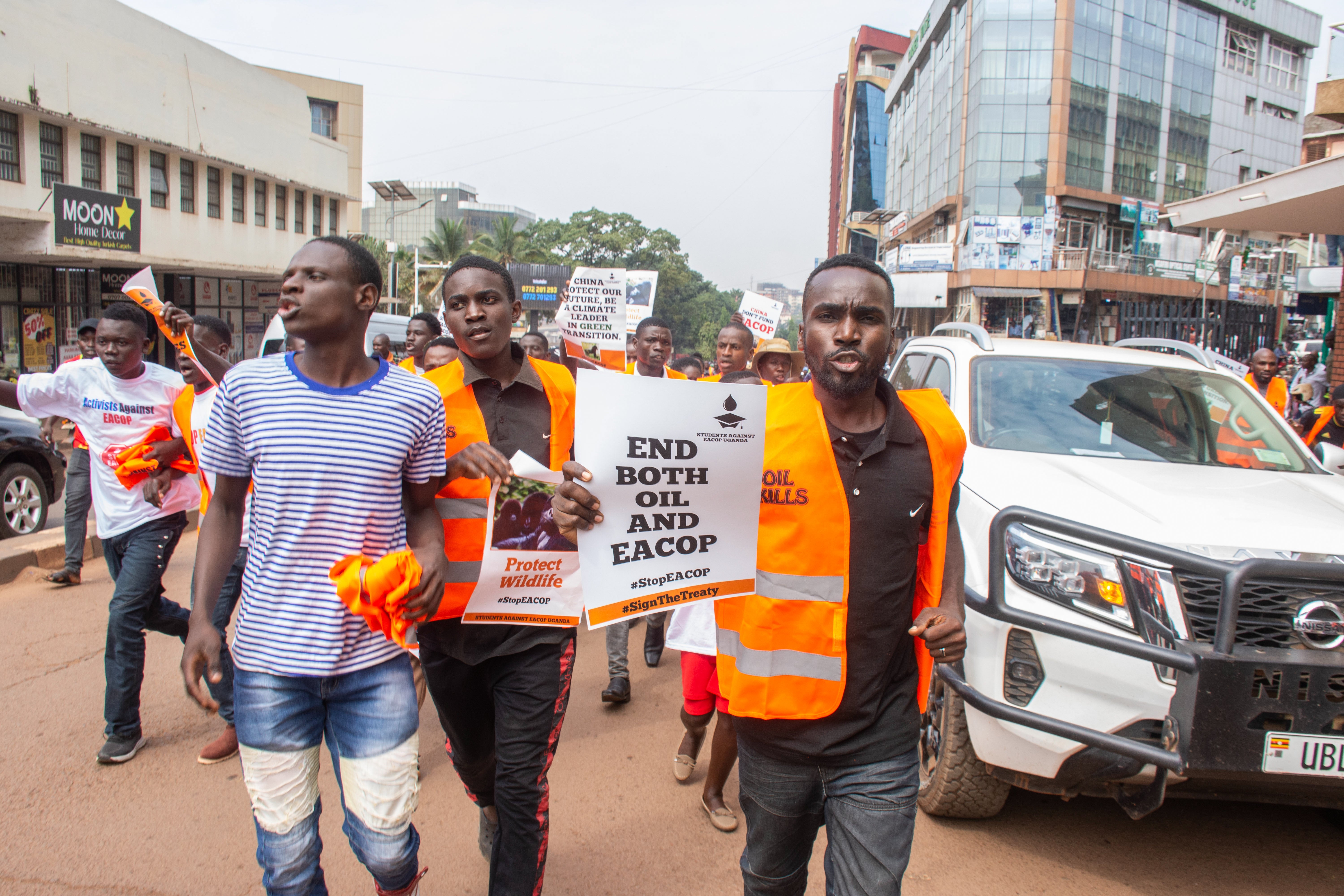 University students shout slogans and display placards during a protest against the East African Crude Oil Pipeline Project (EACOP) in Kampala, Uganda