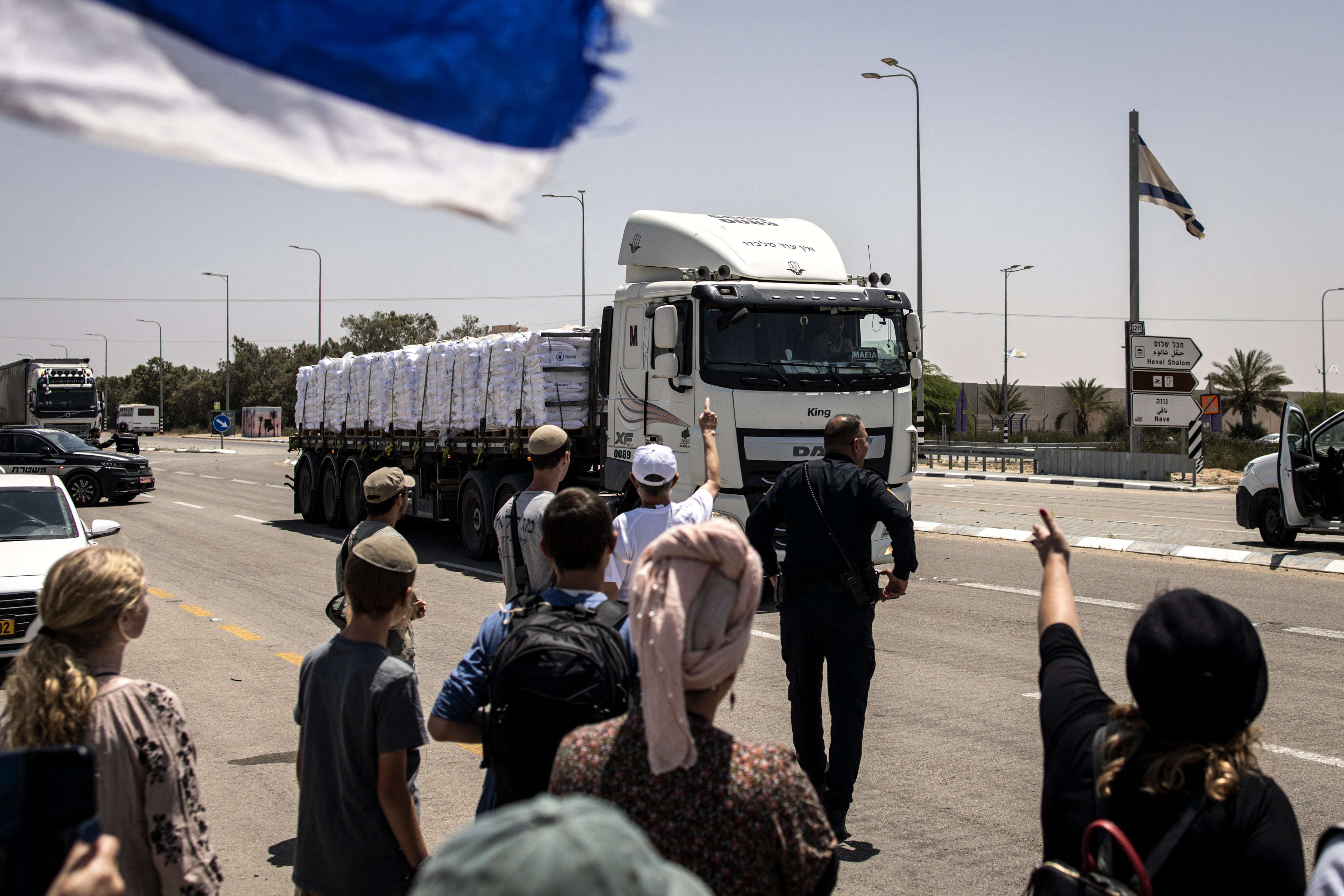 Protesters gesture at a truck driving past during a protest to block humanitarian aid from entering Gaza