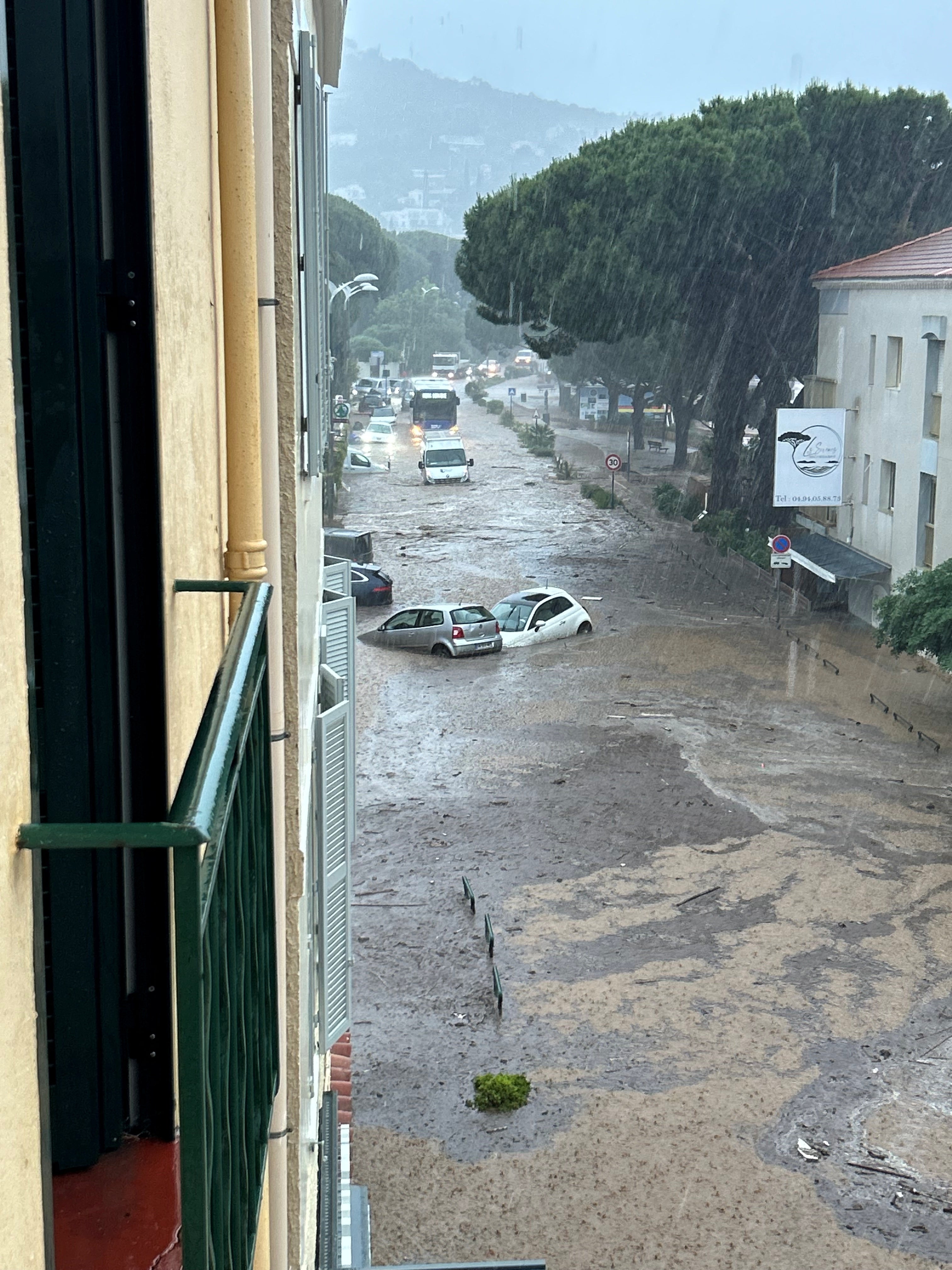 Vehicles are partially submerged in floodwaters, following heavy rainfall, in Le Lavandou