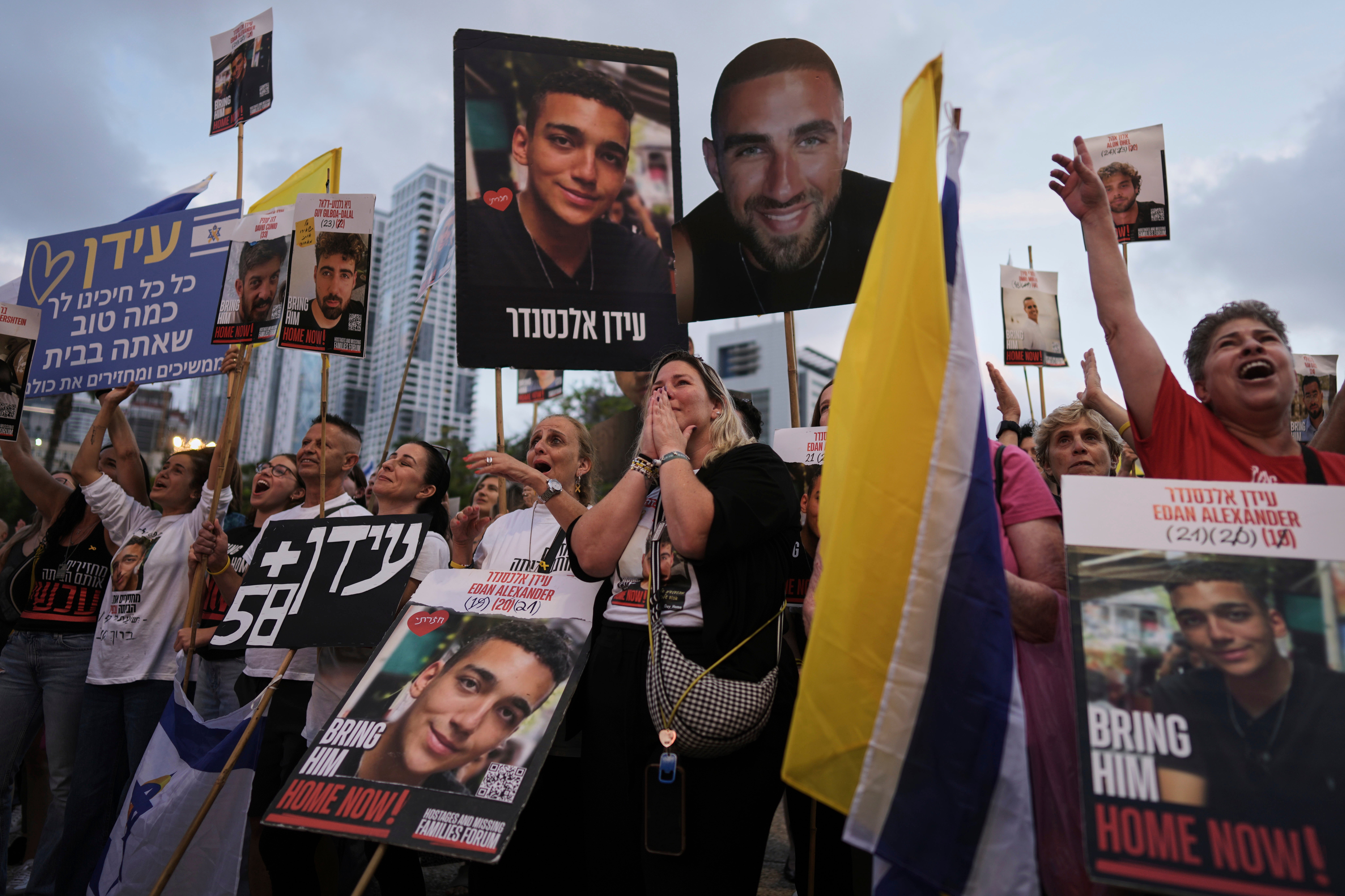 People watch a live broadcast of Israeli-American soldier Edan Alexander's release from Hamas captivity at a plaza known as the hostages square in Tel Aviv on 12 May