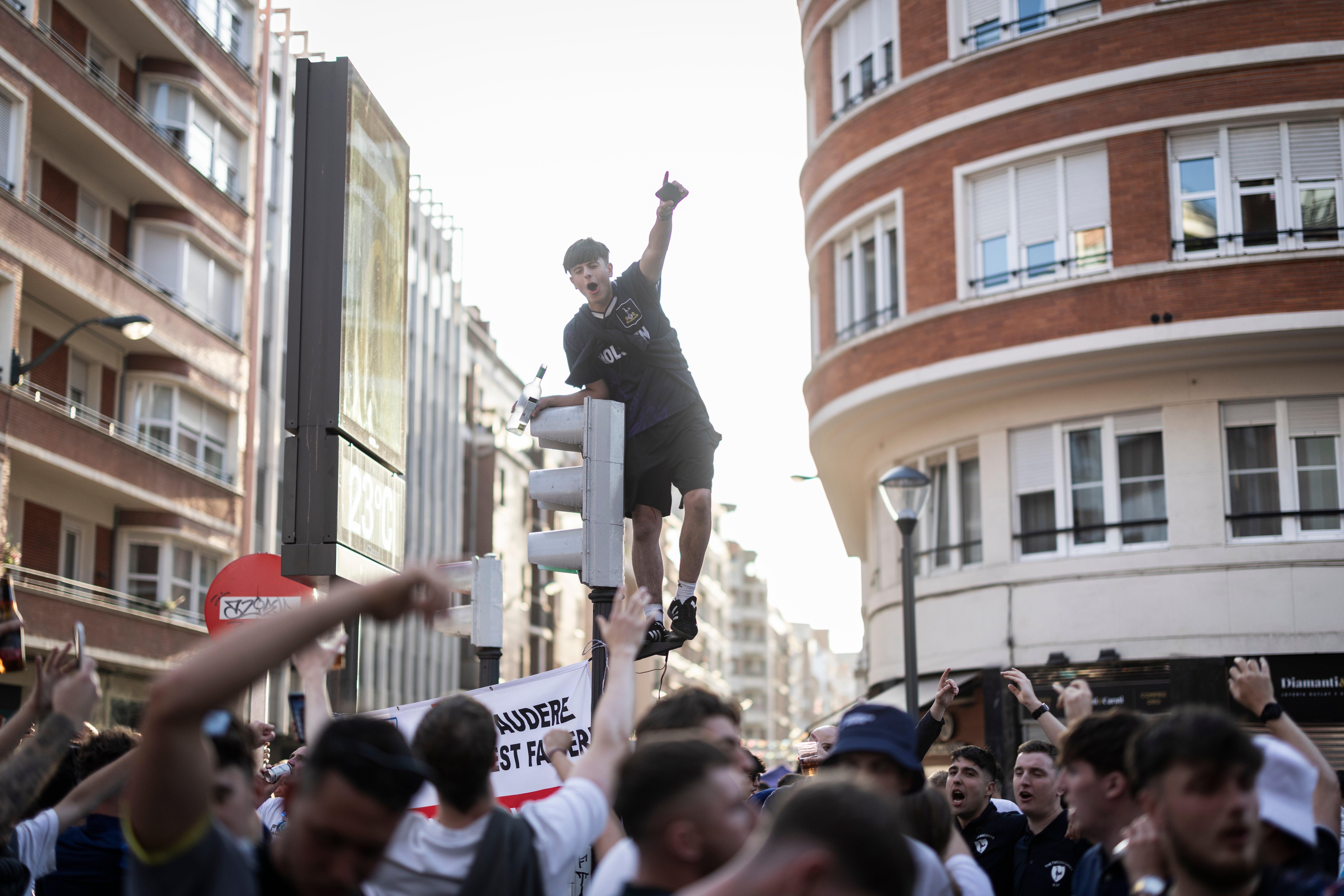 Tottenham Hotspur fans standing on top of traffic lights in Bilbao ahead of the UEFA Europa League Final 2025 between Tottenham Hotspur and Manchester United on 20 May
