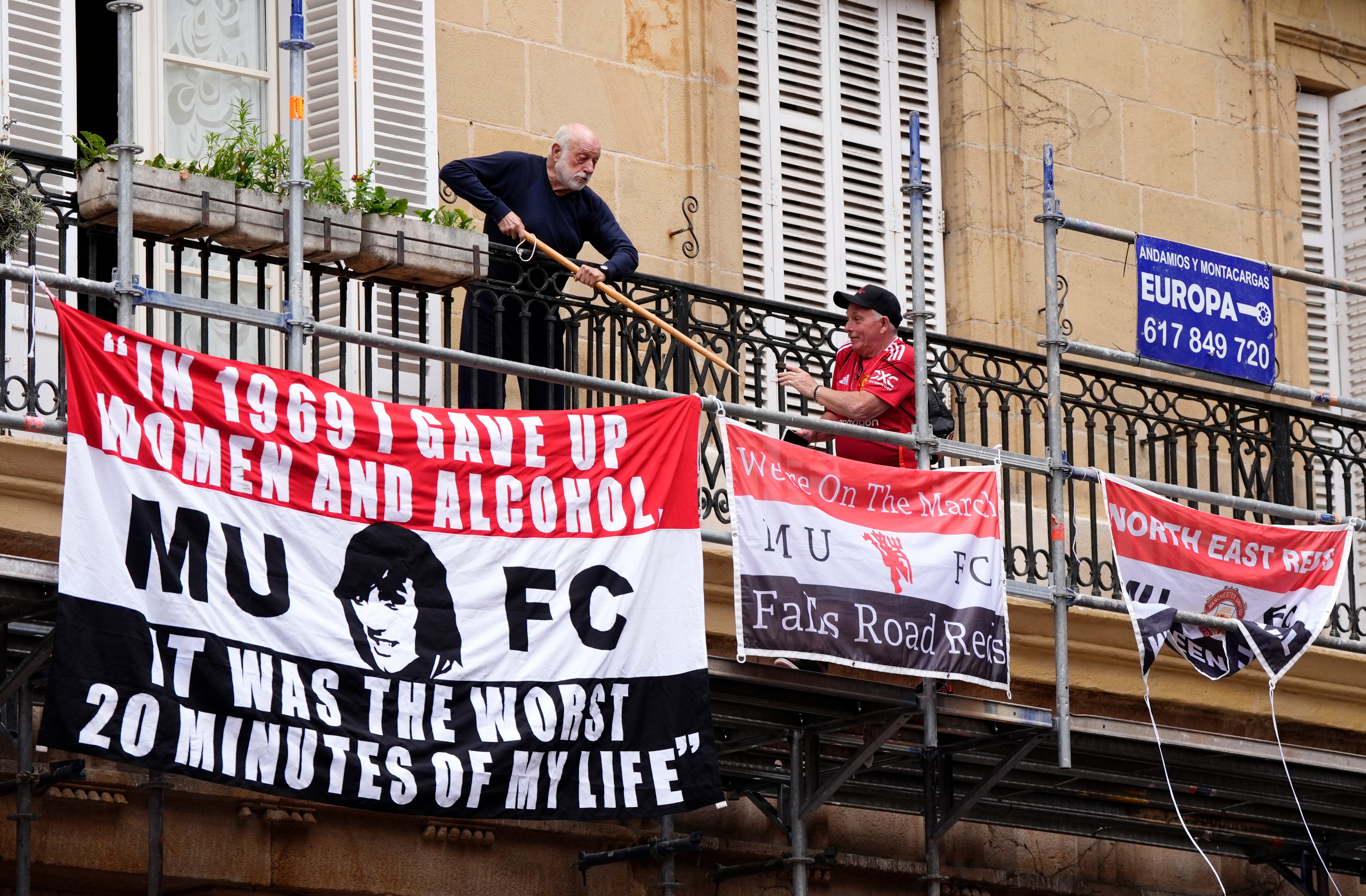 A local resident fending off Manchester United fans who put up banners above Plaza Nueva in Bilbao before the UEFA Europa League final at the Estadio de San Mames in Bilbao, Spain on 21 May