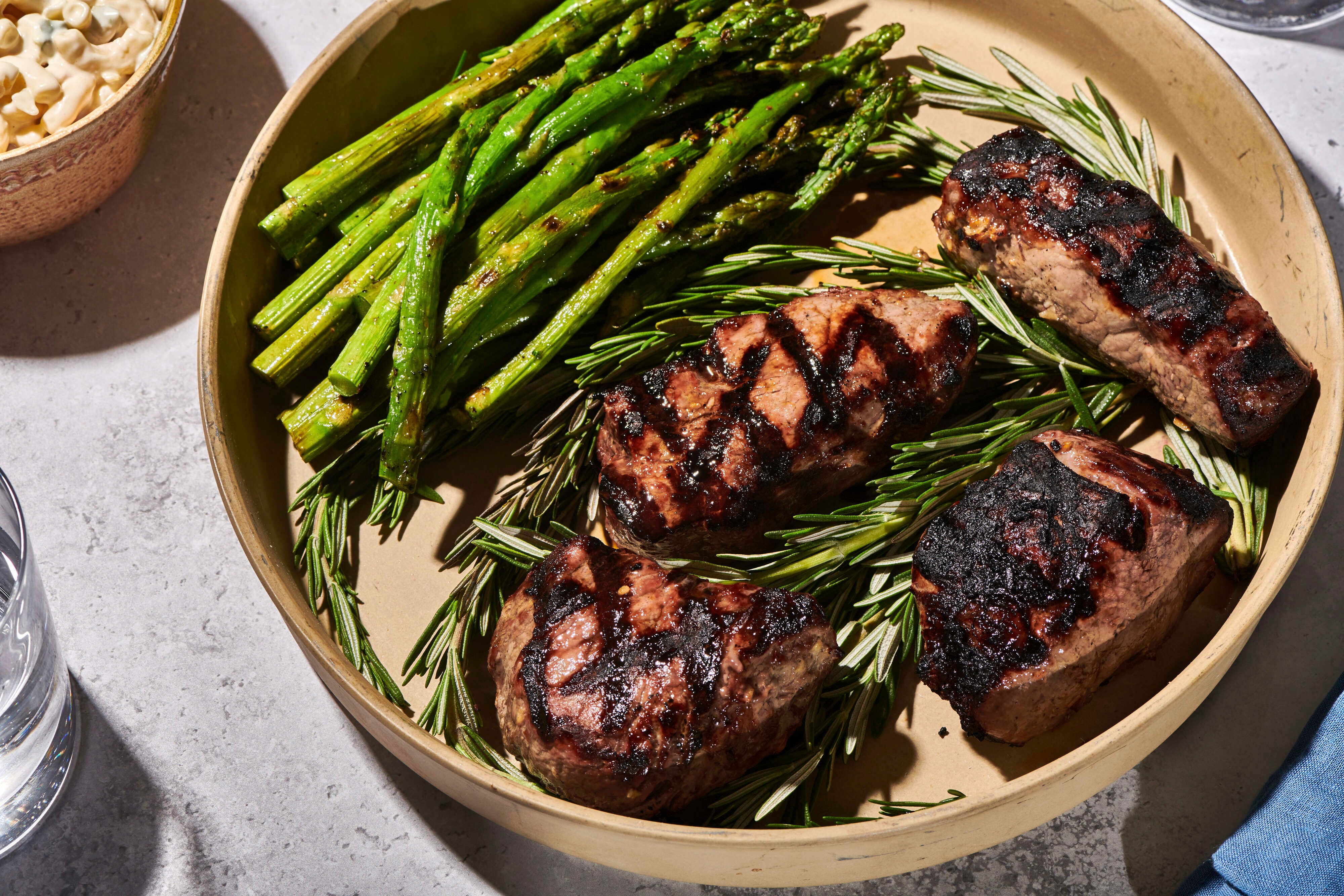 A grilled top sirloin on a plate with asparagus