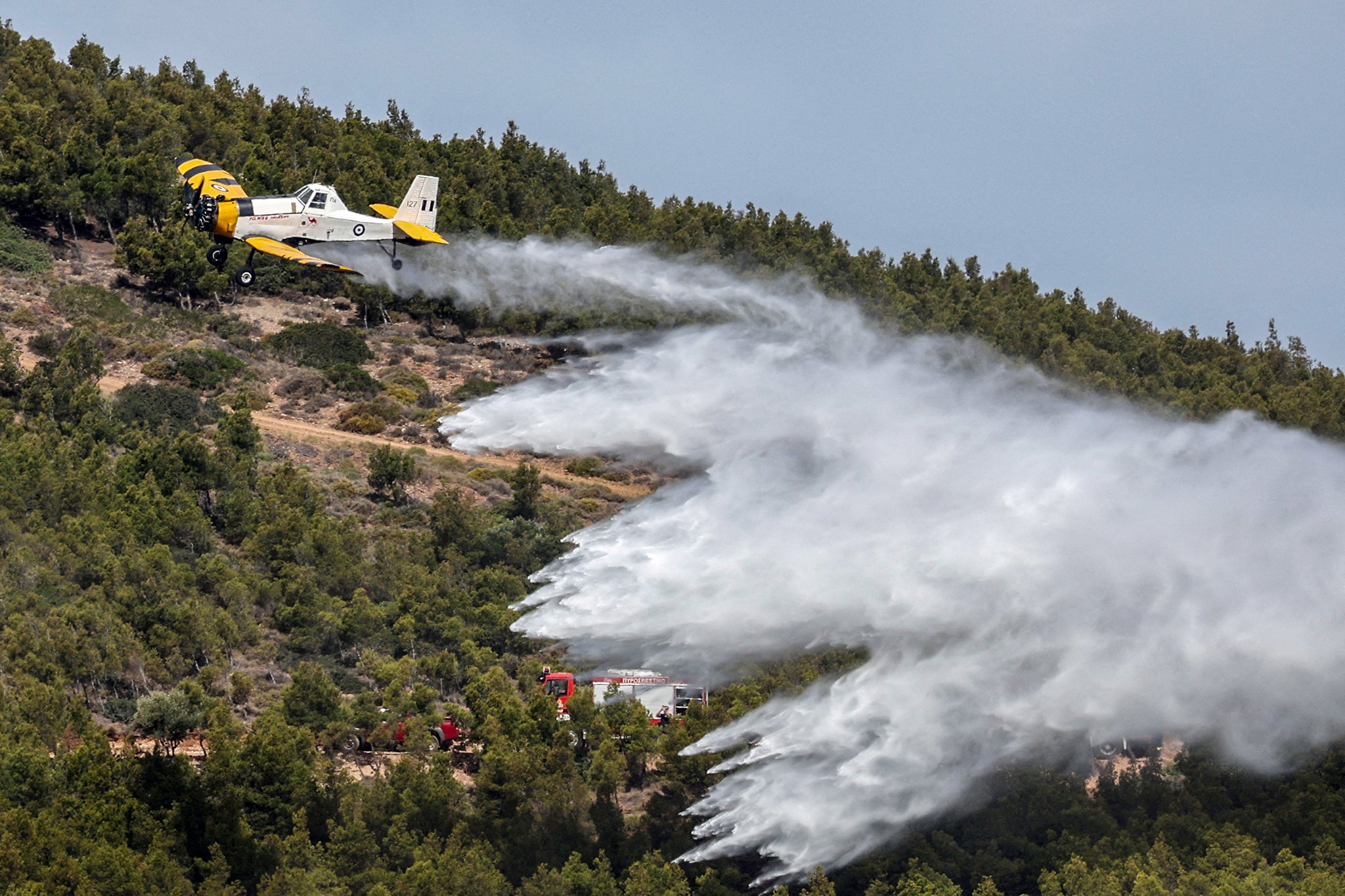A PZL firefighting plane drops water, during a wide scale readiness training exercise, as the country enters its peak fire season, in Lavrio, Greece, May 22, 2025