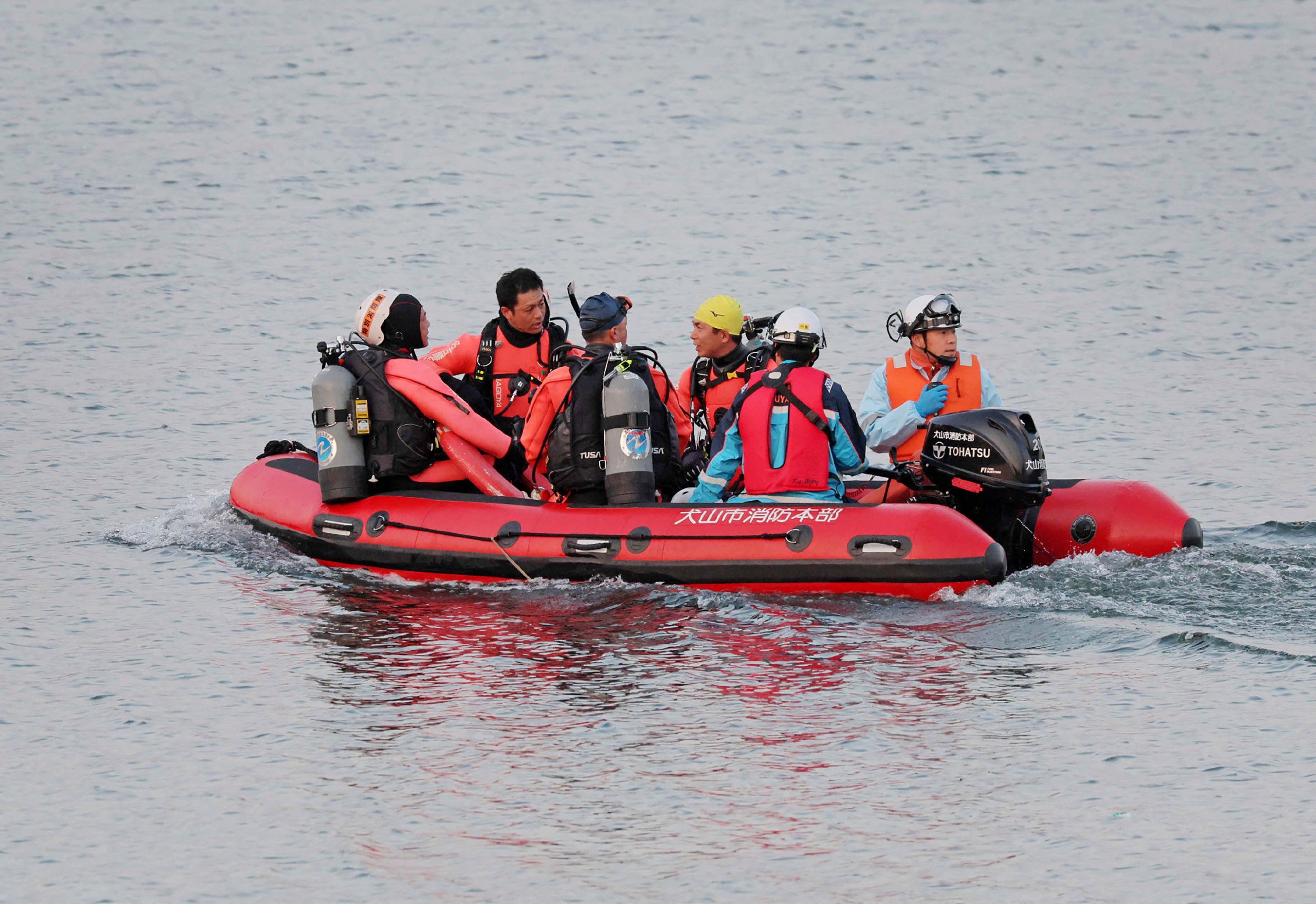 Firefighters search the area where a Japan Air Self-Defense Force training plane T-4 crashed, at Lake Iruka in Inuyama City, Aichi Prefecture