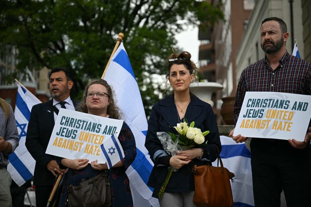 <p>People hold signs and Israeli national flags in  signs support outside the Capital Jewish Museum following a shooting that killed two staff members of the Israeli embassy in Washington, DC</p>