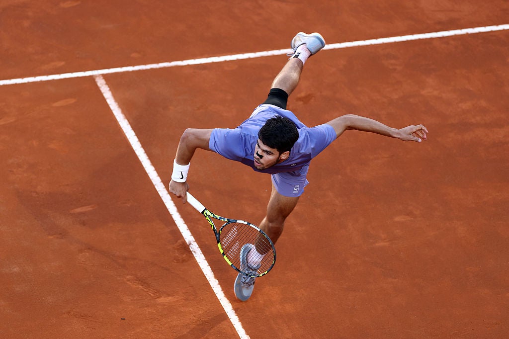 Carlos Alcaraz serves against Jannik Sinner during the Italian Open final